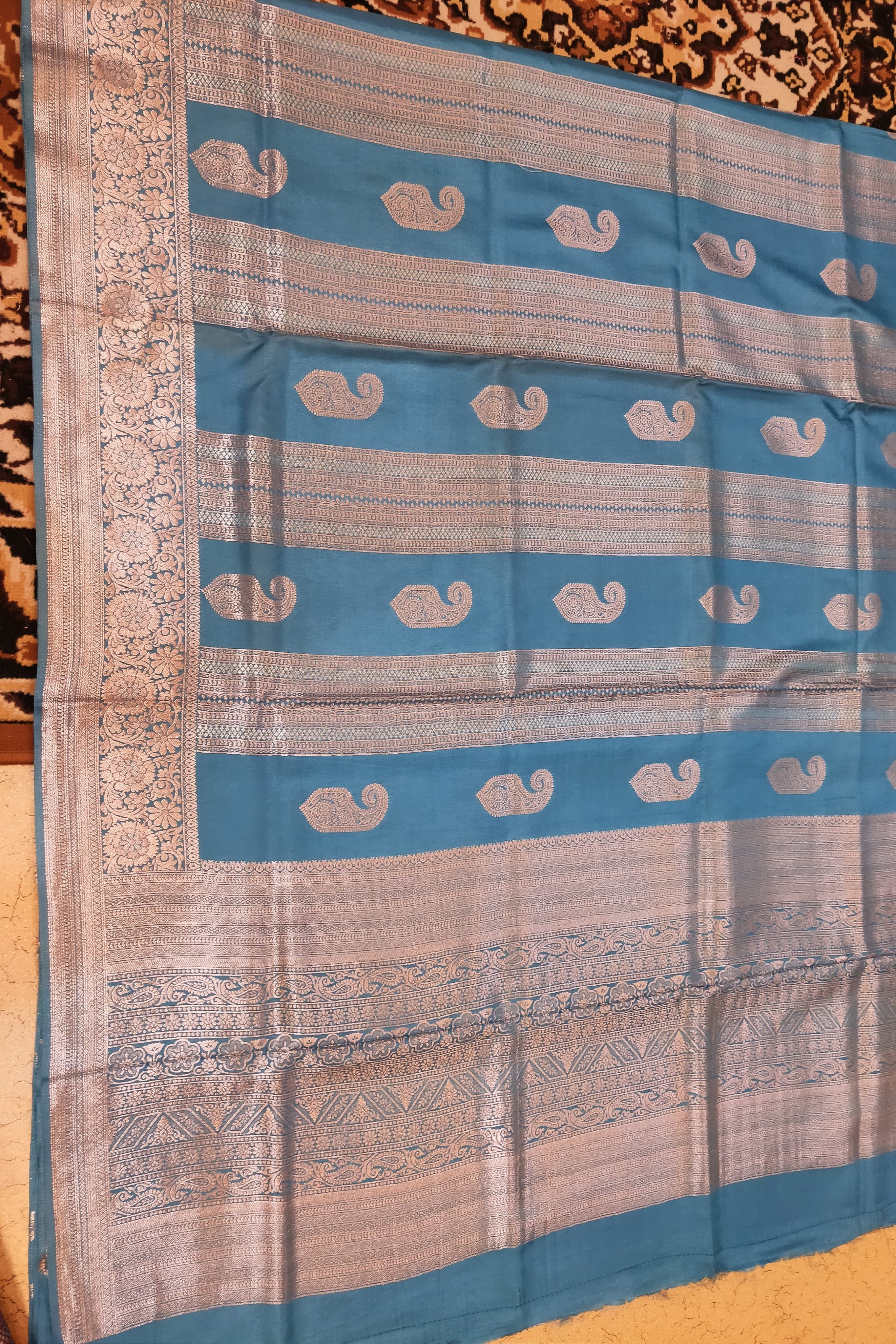Saree with blue and beige pattern on a textured surface