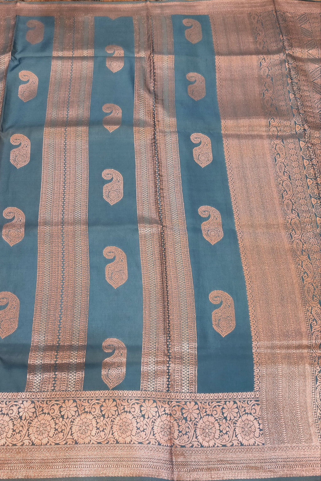 Traditional fabric with blue and beige patterns on a wooden surface