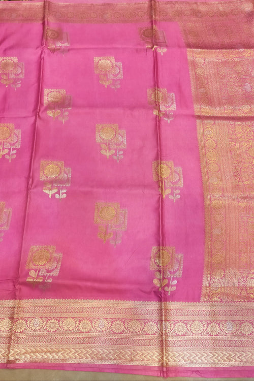 Pink saree with gold patterns on a plain background