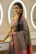 Woman wearing a traditional saree in a well-lit room with mirrors.