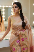 Woman in a beige saree with floral patterns in a mirror-lined room.