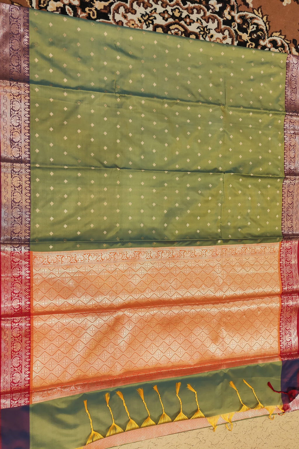 Green and orange saree with a patterned background