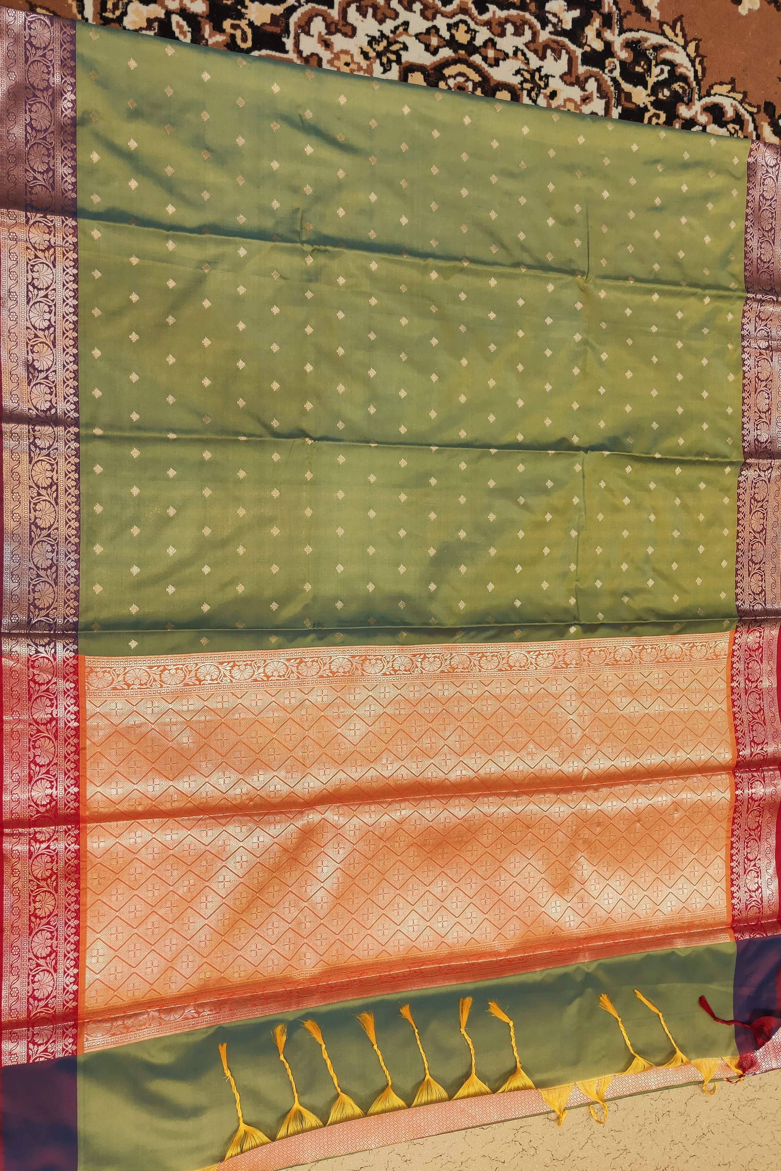 Green and orange saree with a patterned background