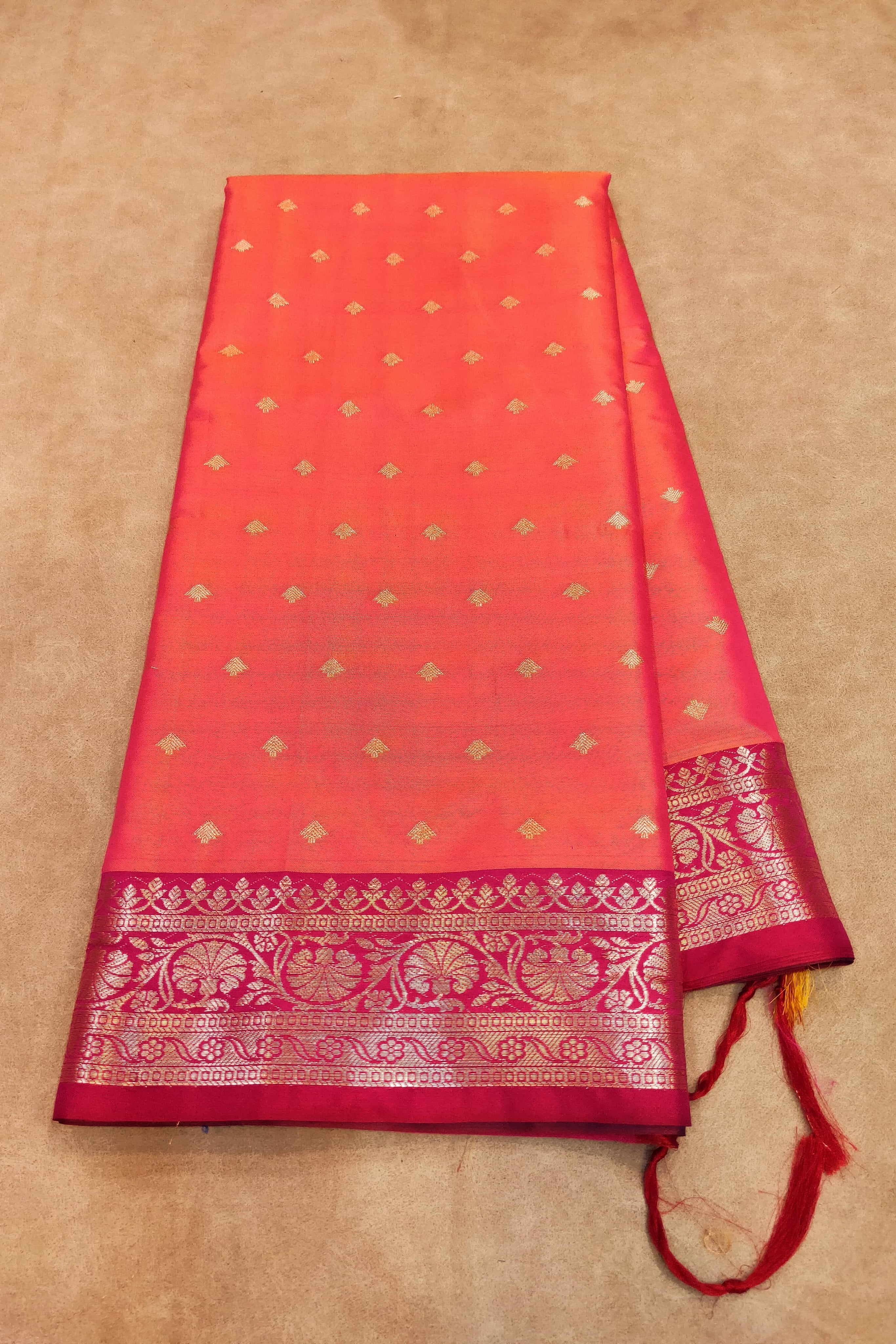 Red saree with gold patterns on a beige background
