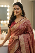 Woman in a red saree with gold patterns in a vanity mirror setting.