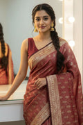 Woman wearing a traditional saree in front of a mirror
