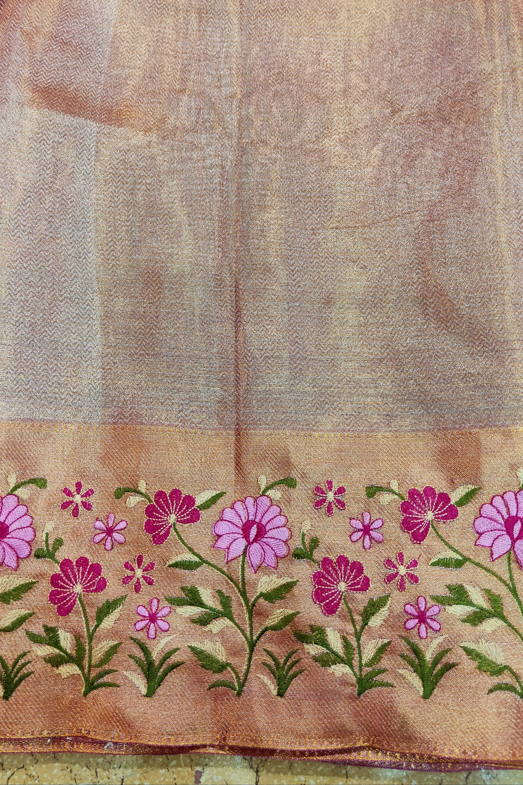 Textile with floral embroidery on a brown background
