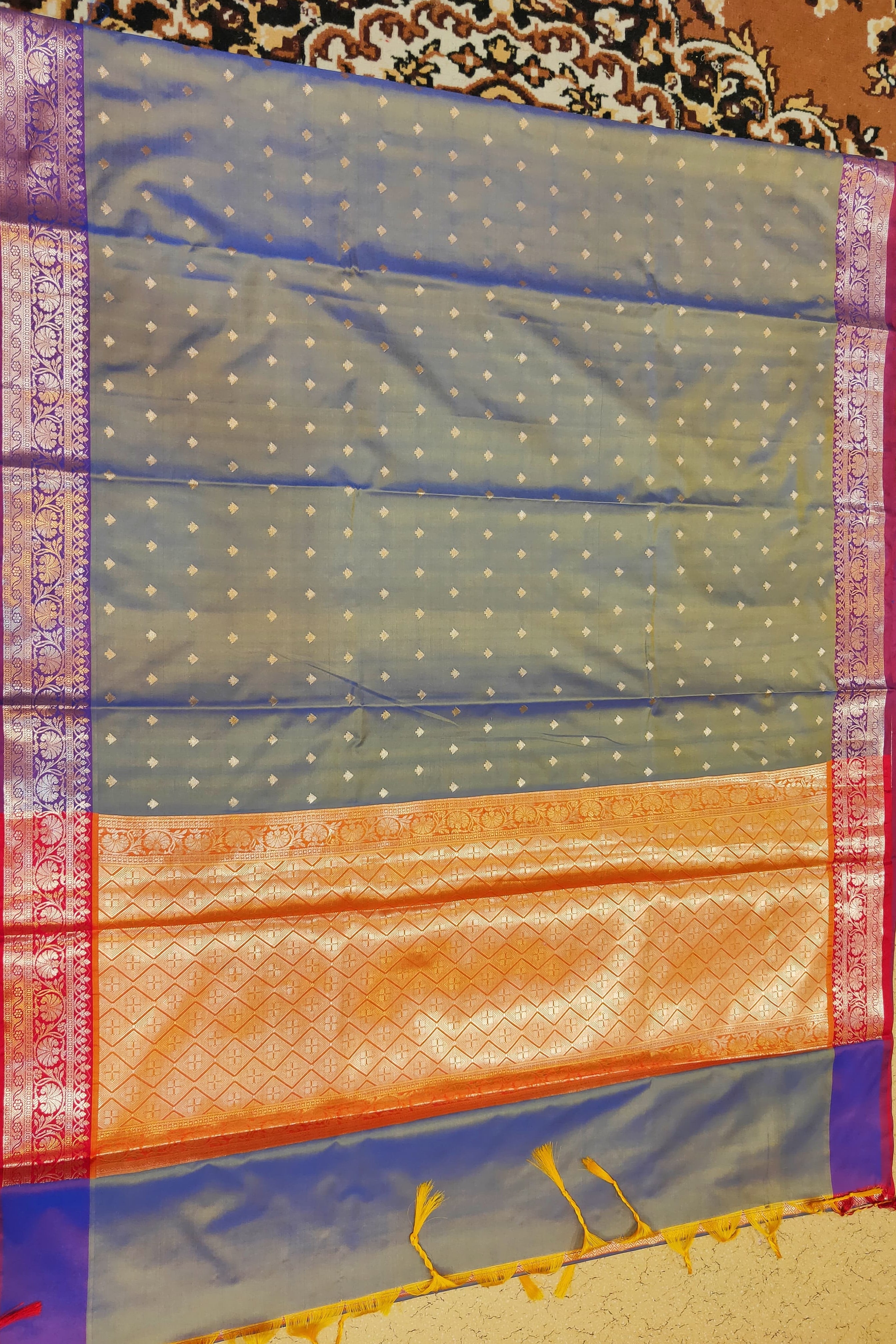Traditional saree with a patterned border on a textured surface