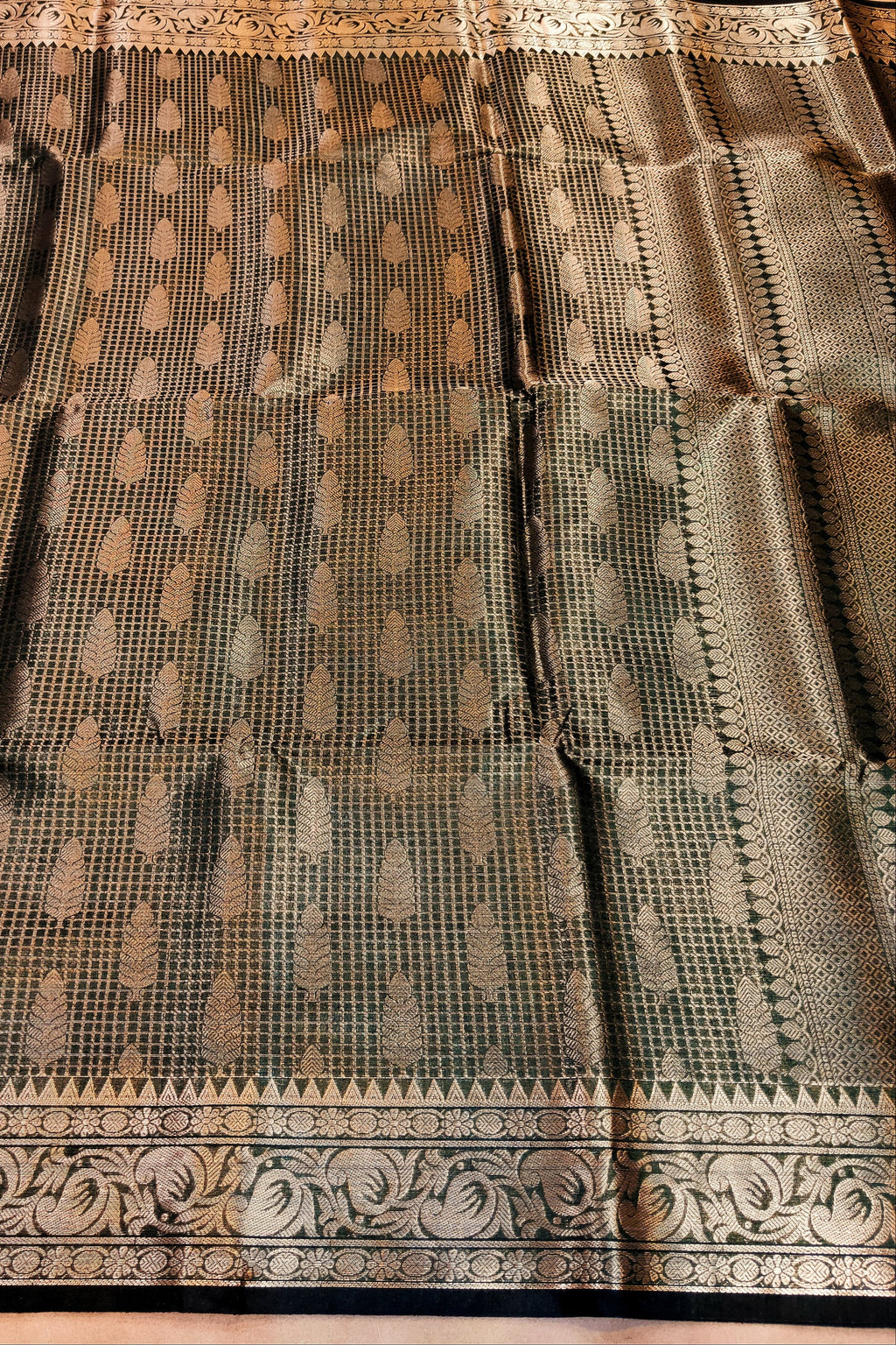 Traditional saree with intricate patterns on a wooden surface