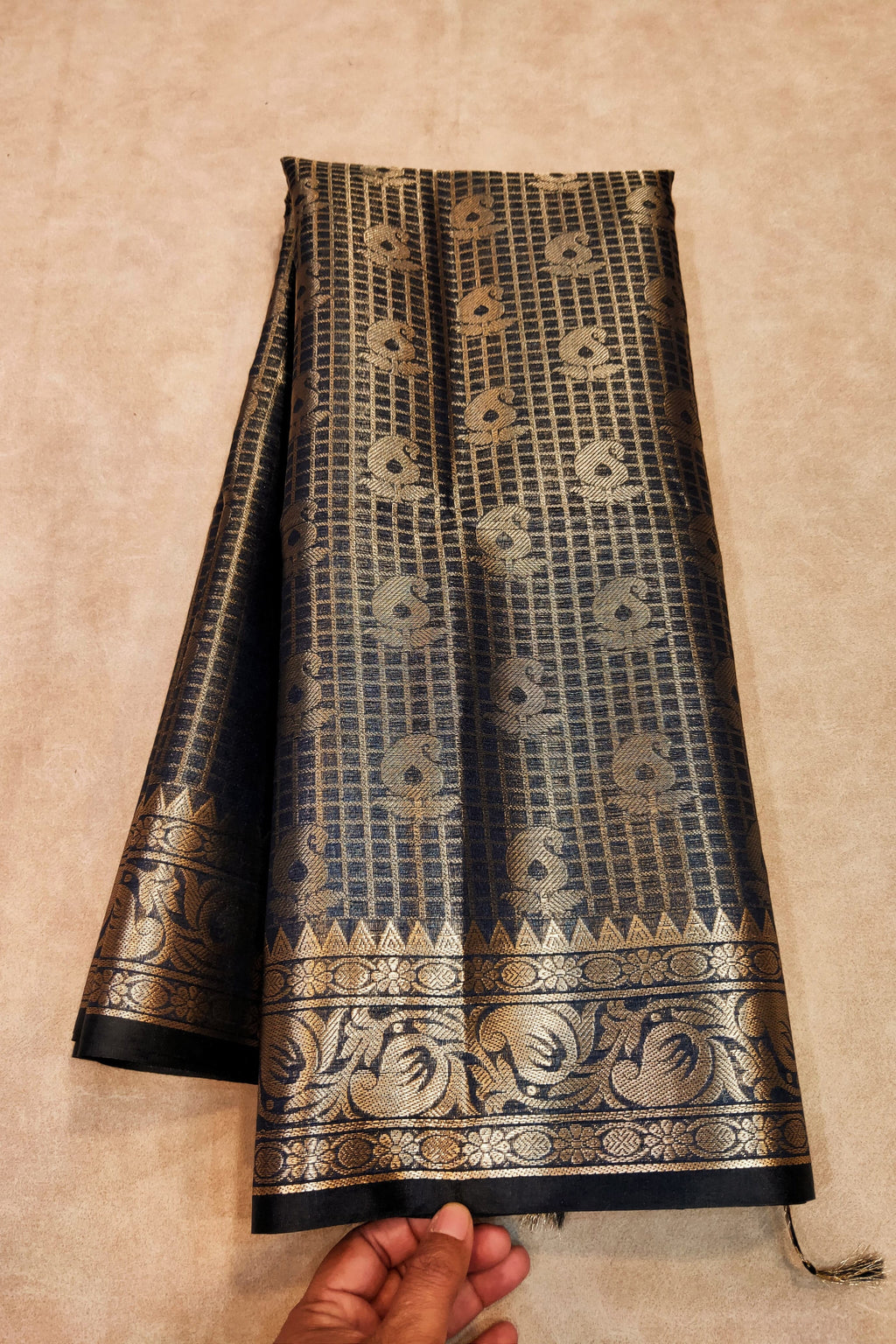 Black and gold patterned fabric on a beige background