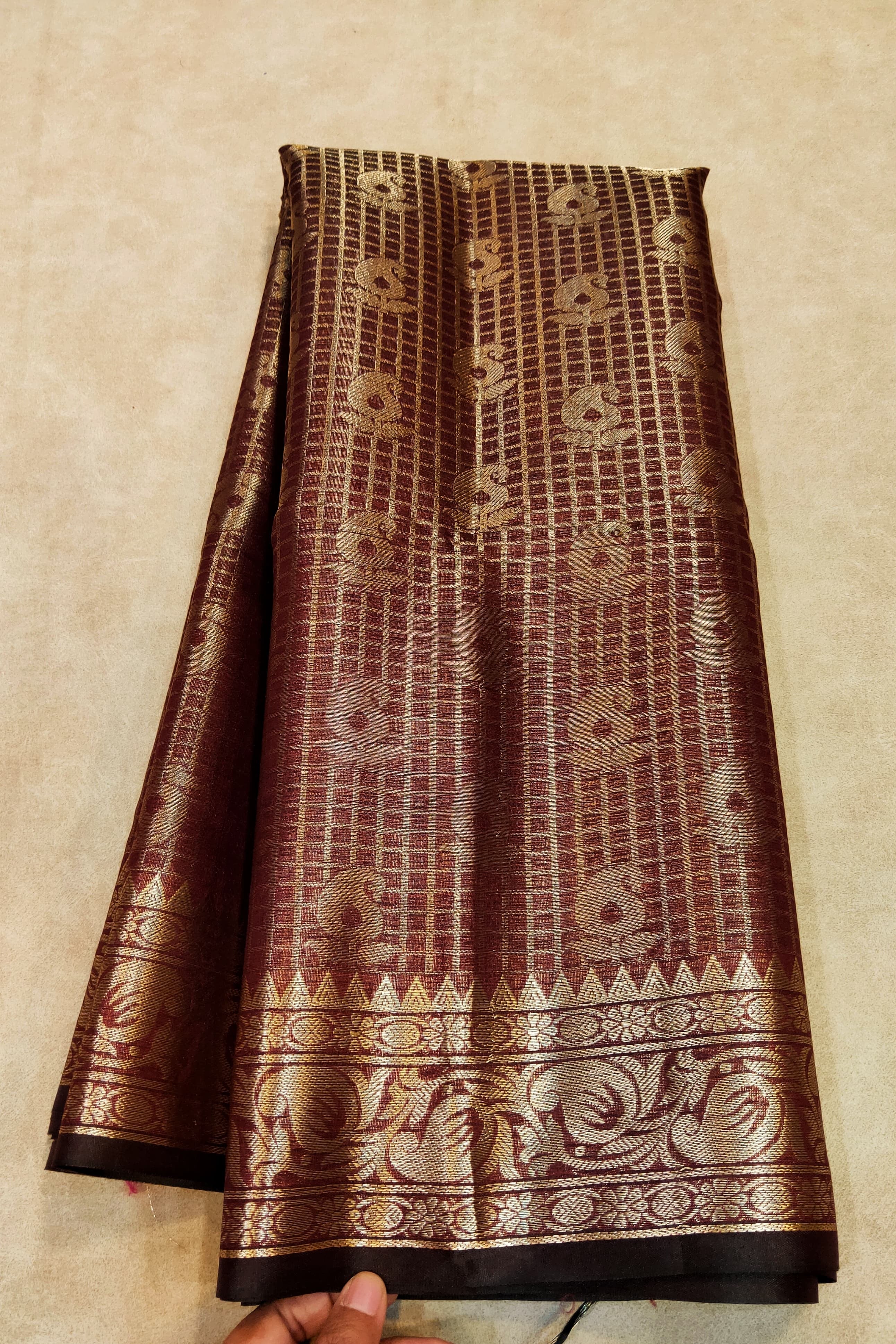 Brown and gold patterned fabric on a beige background