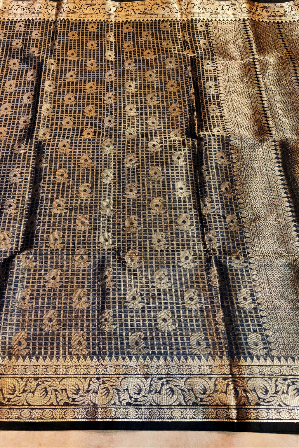 Black and gold patterned fabric on a wooden surface