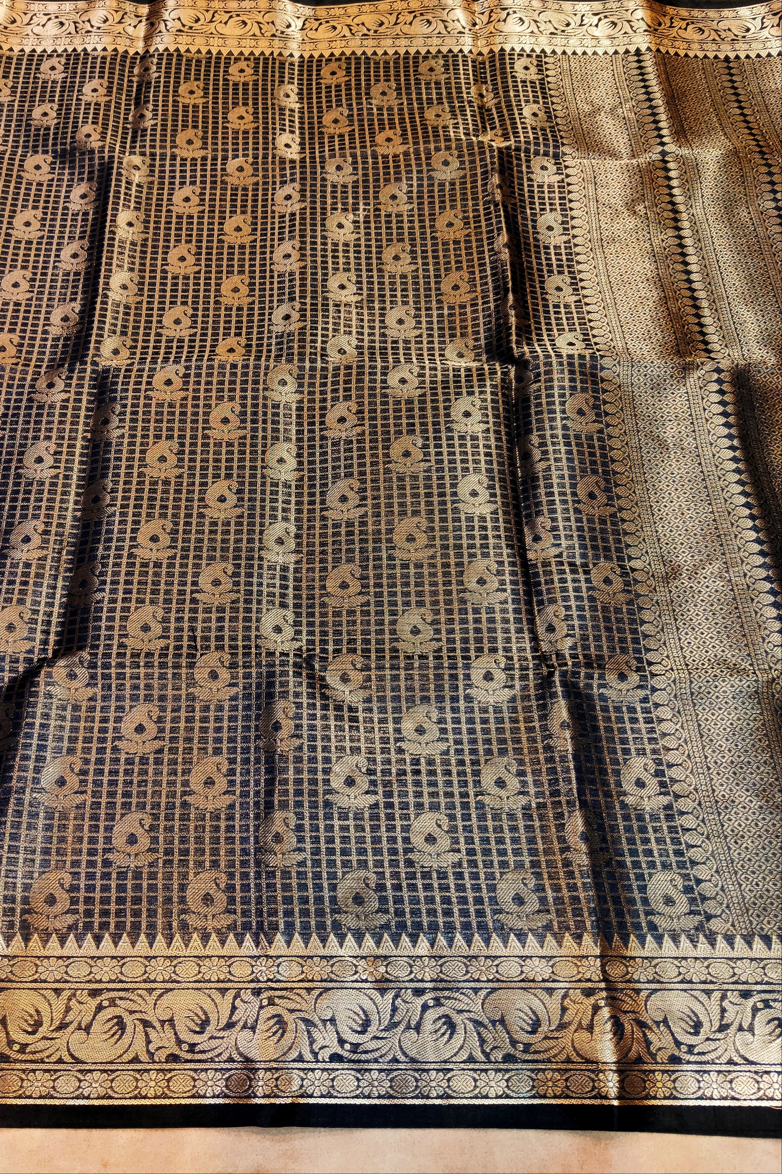 Black and gold patterned fabric on a wooden surface