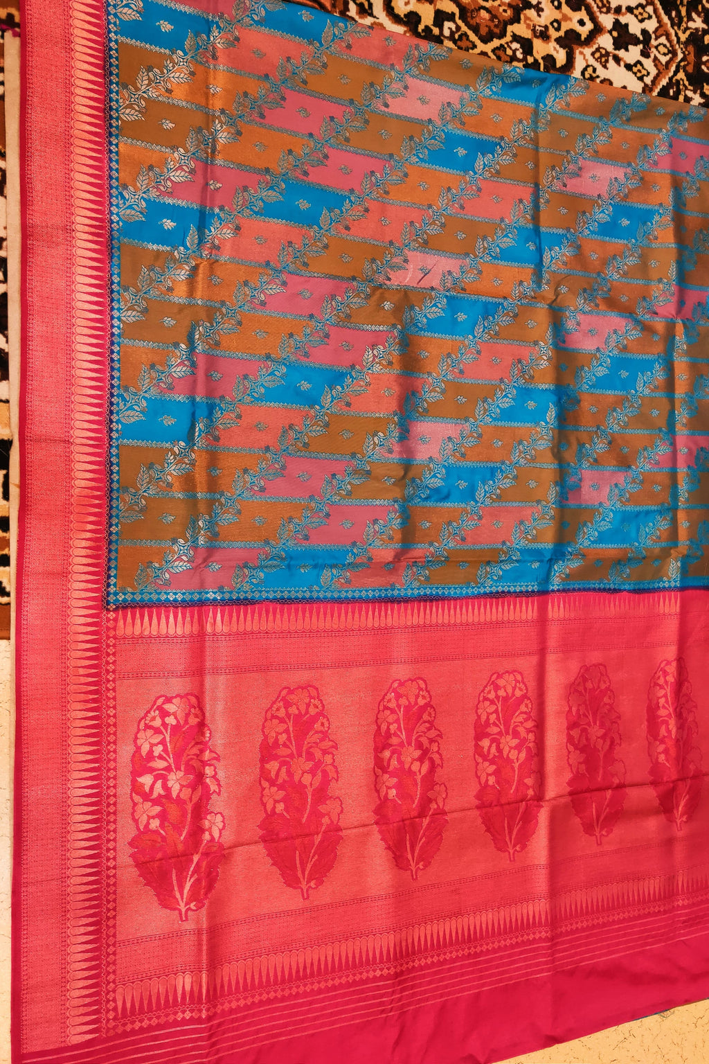Saree with a pink and blue pattern on a wooden surface