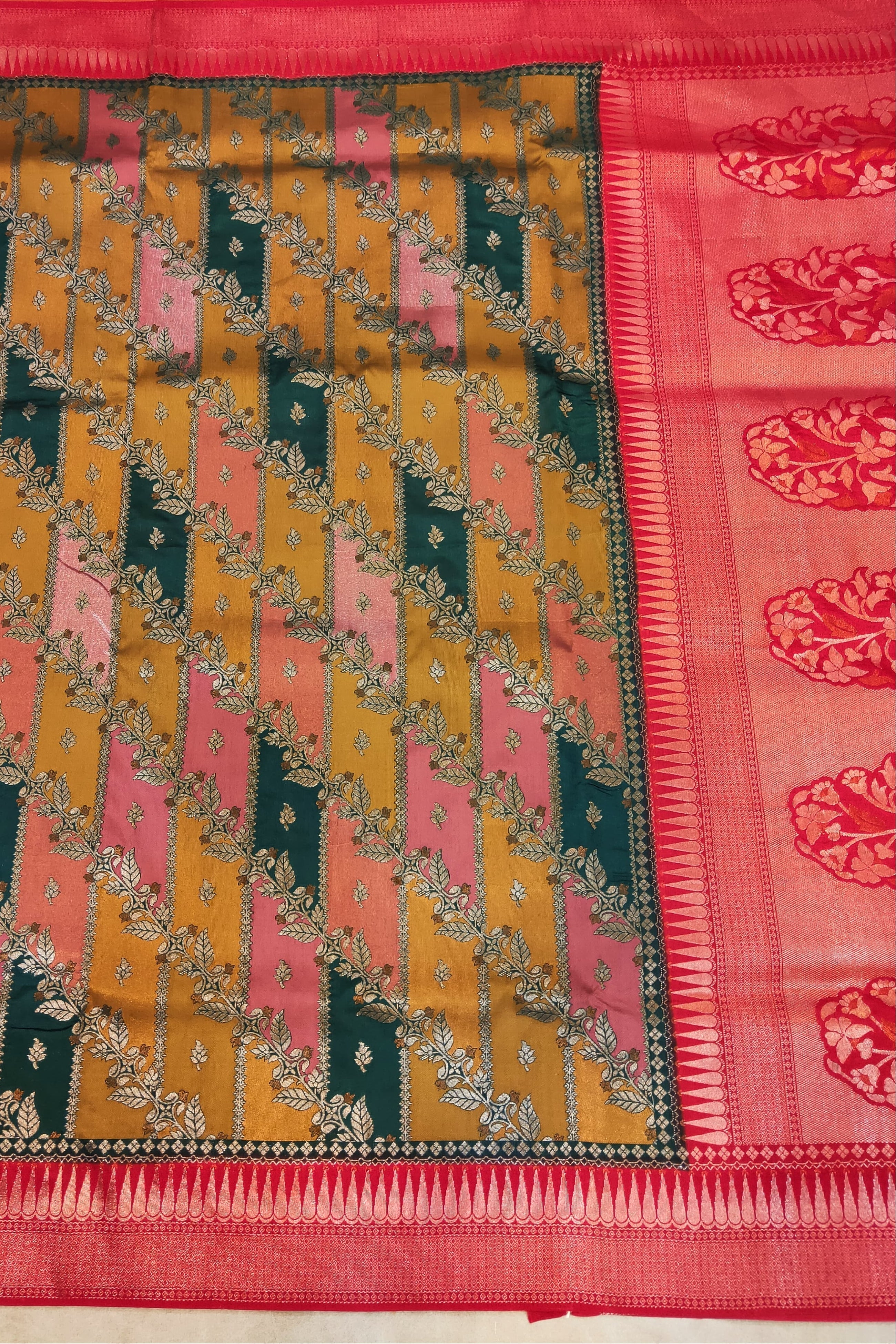 Colorful patterned fabric with a red border on a plain background