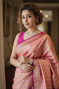 Woman in a pink saree with a blurred indoor background