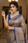 Woman wearing a traditional saree with a blue blouse in an indoor setting