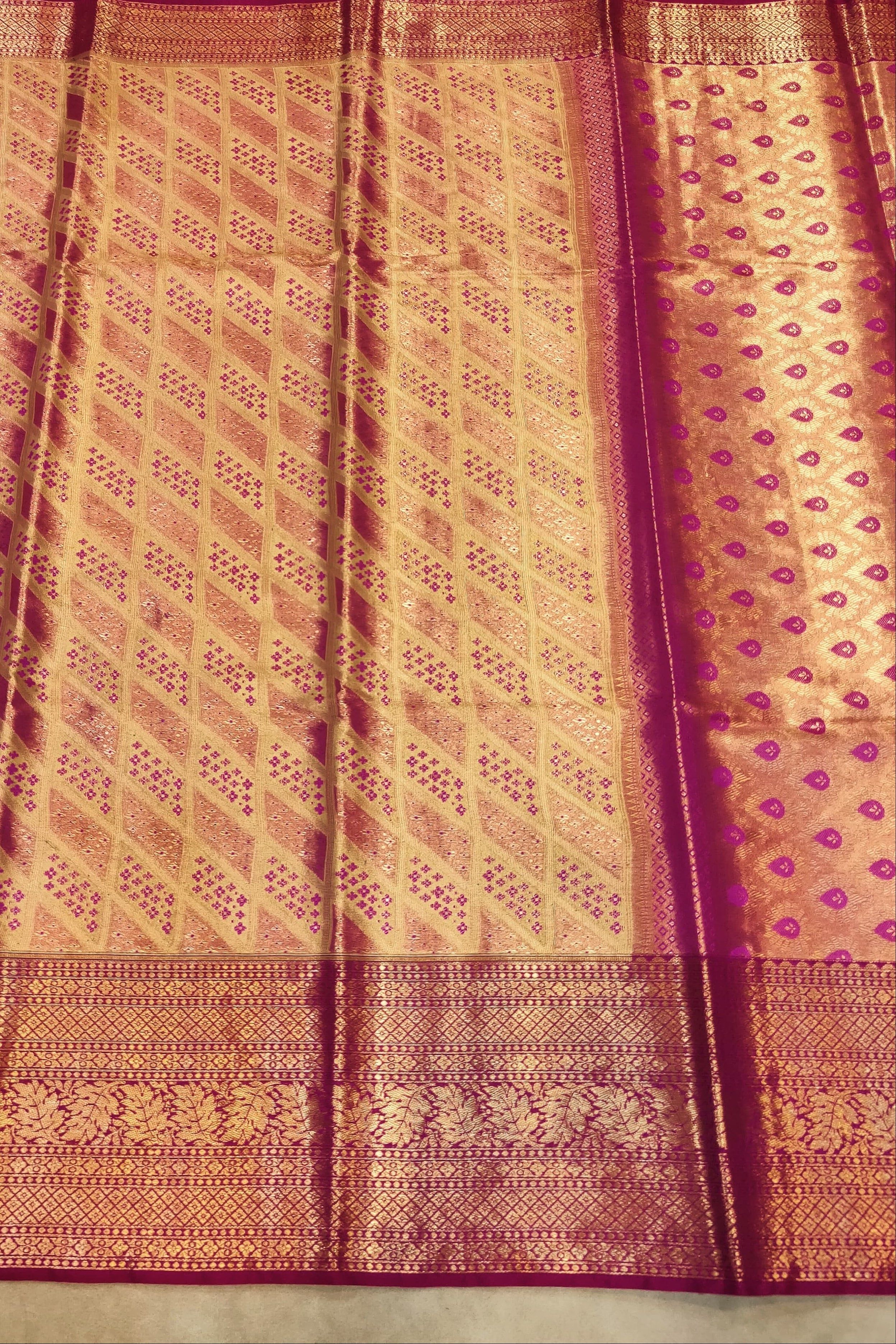 Traditional saree with a pink and gold pattern on a plain background