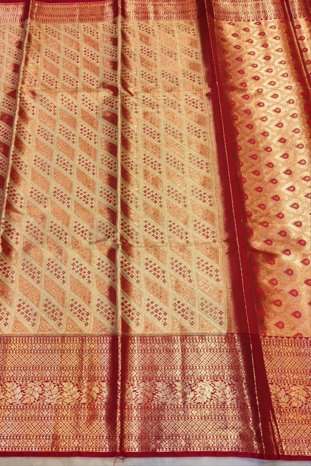 Traditional patterned fabric with red and orange colors on a plain background