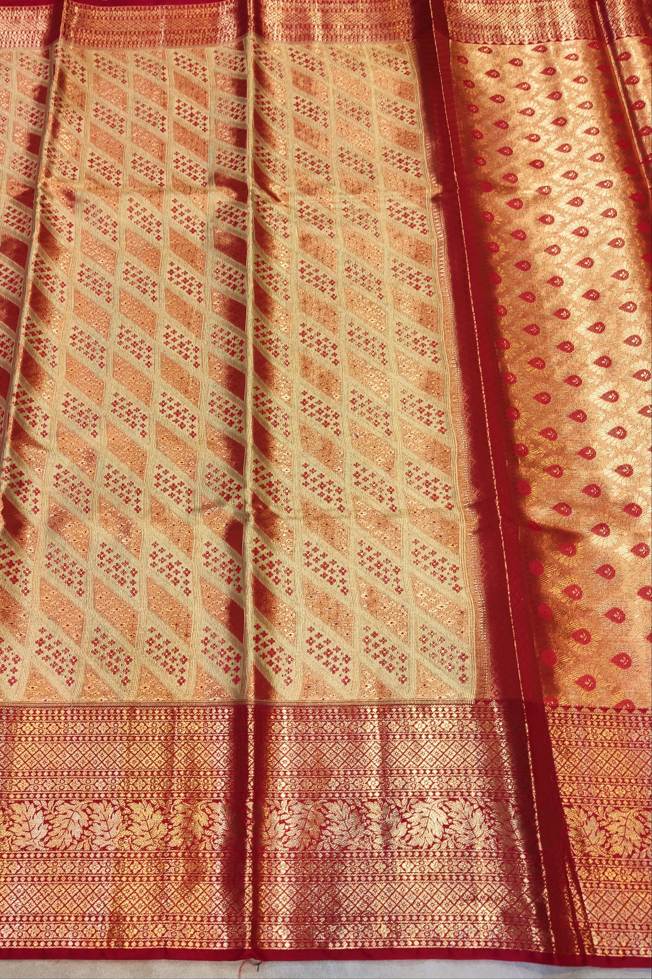 Traditional patterned fabric with red and orange colors on a plain background