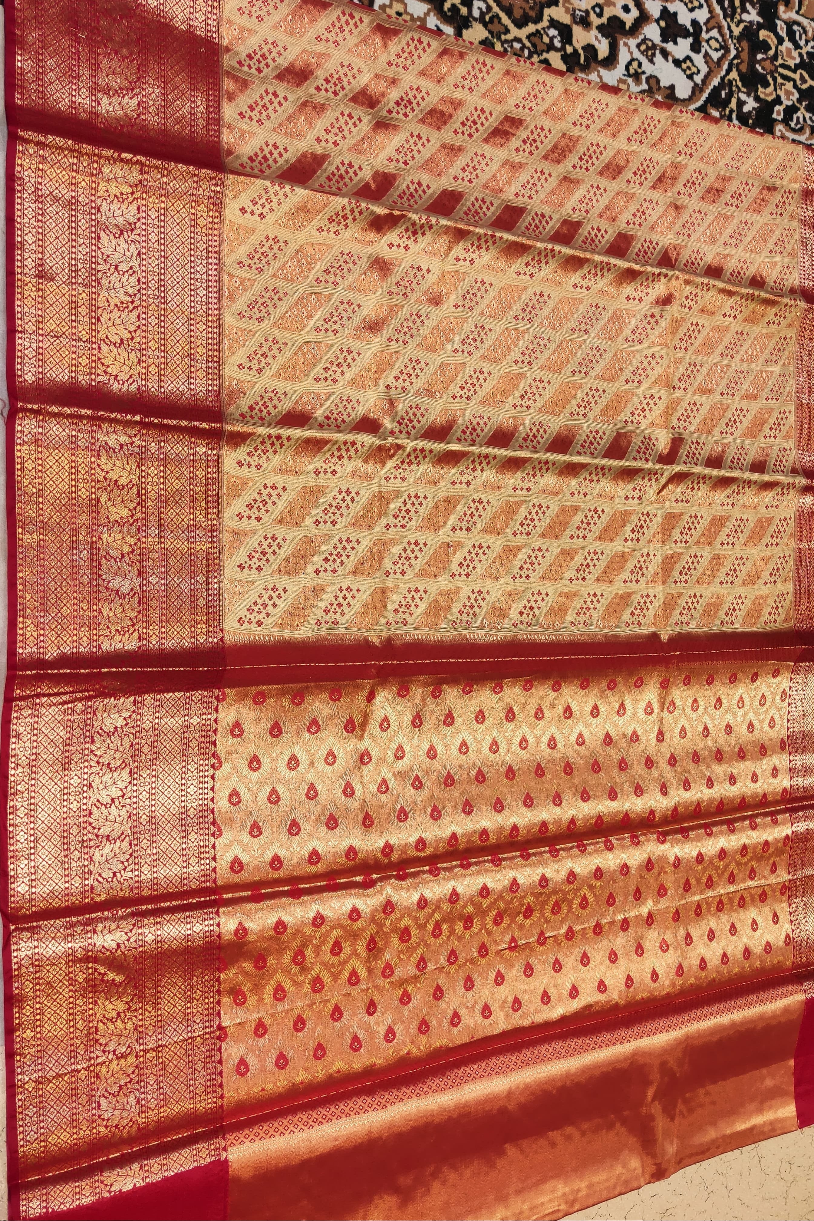 Red and gold patterned fabric on a plain background