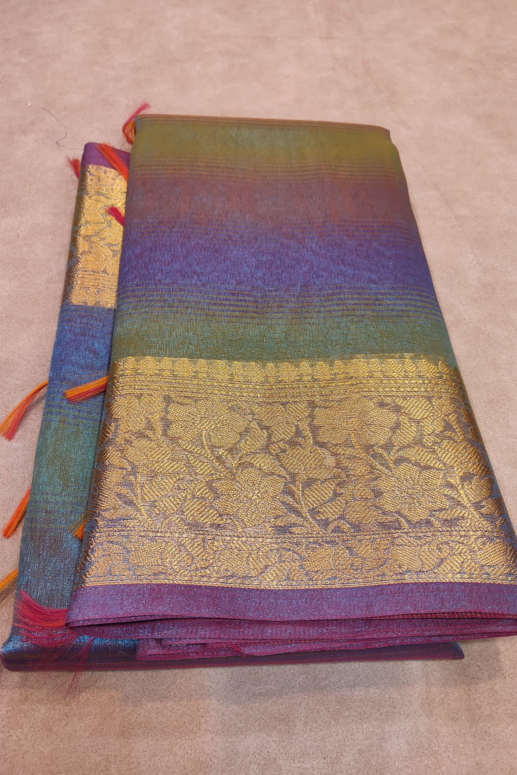 Folded fabric with colorful patterns on a beige surface