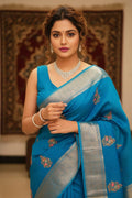 Woman in a blue saree with silver border indoors