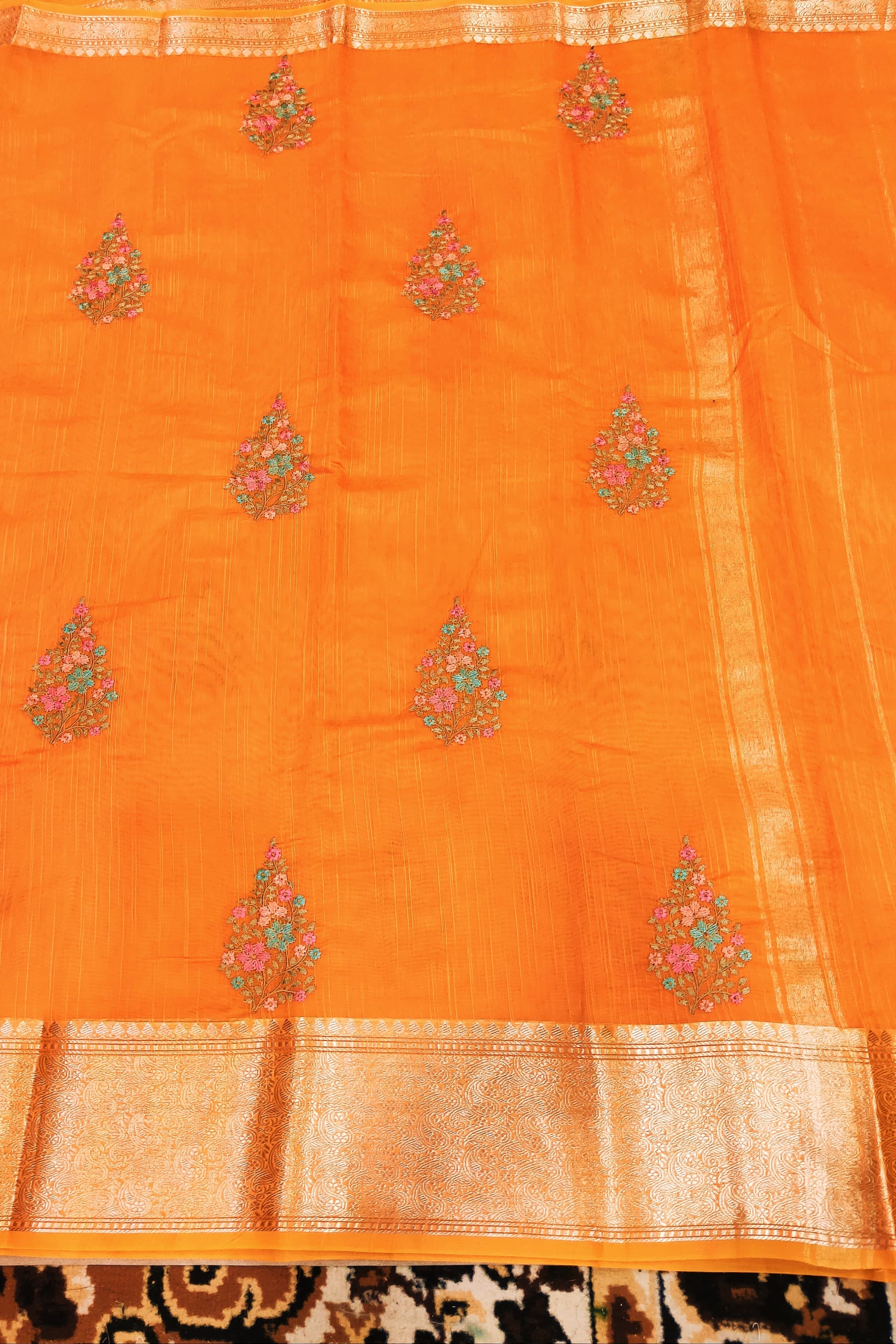 Orange fabric with floral patterns on a patterned surface