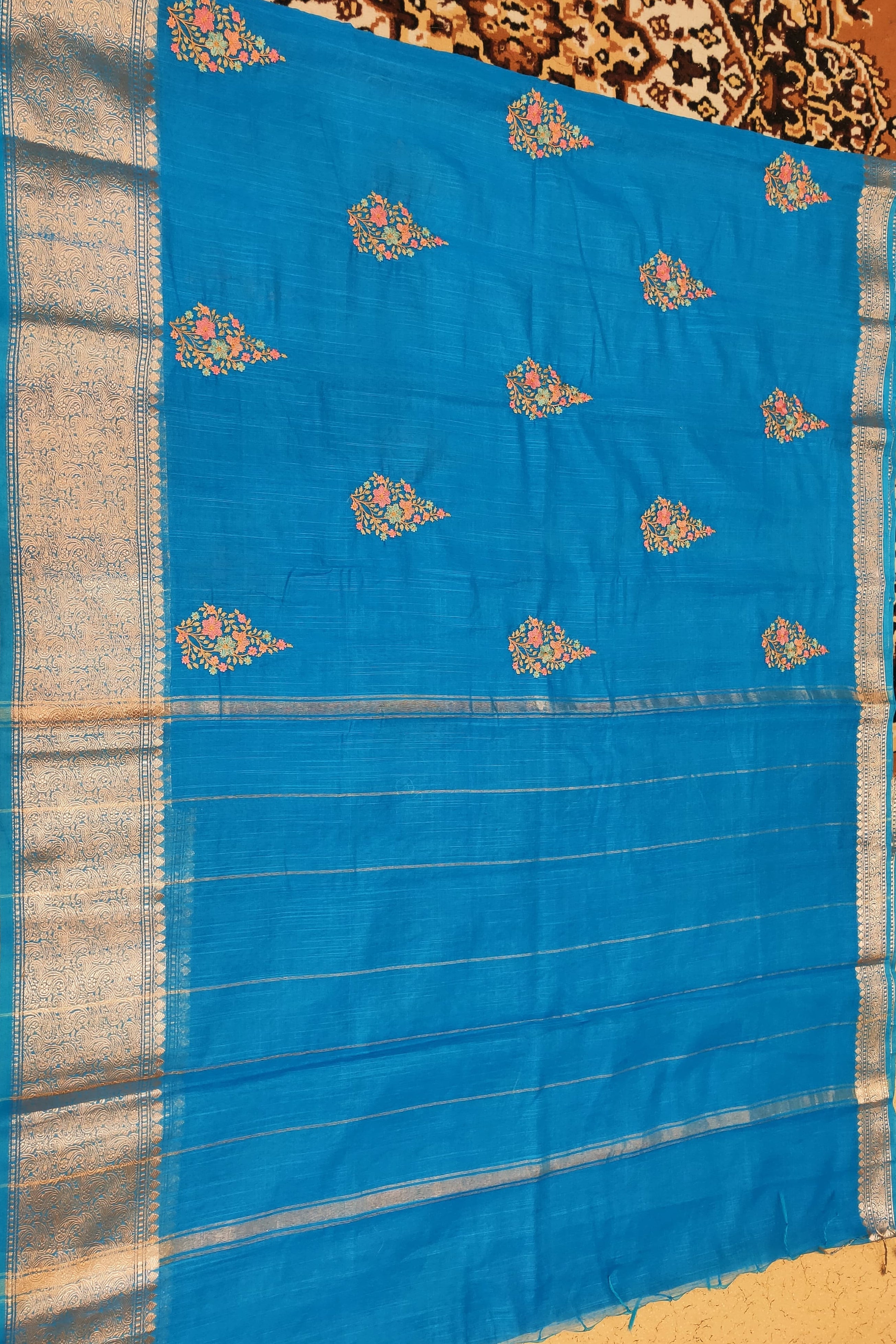 Blue saree with floral patterns on a textured background
