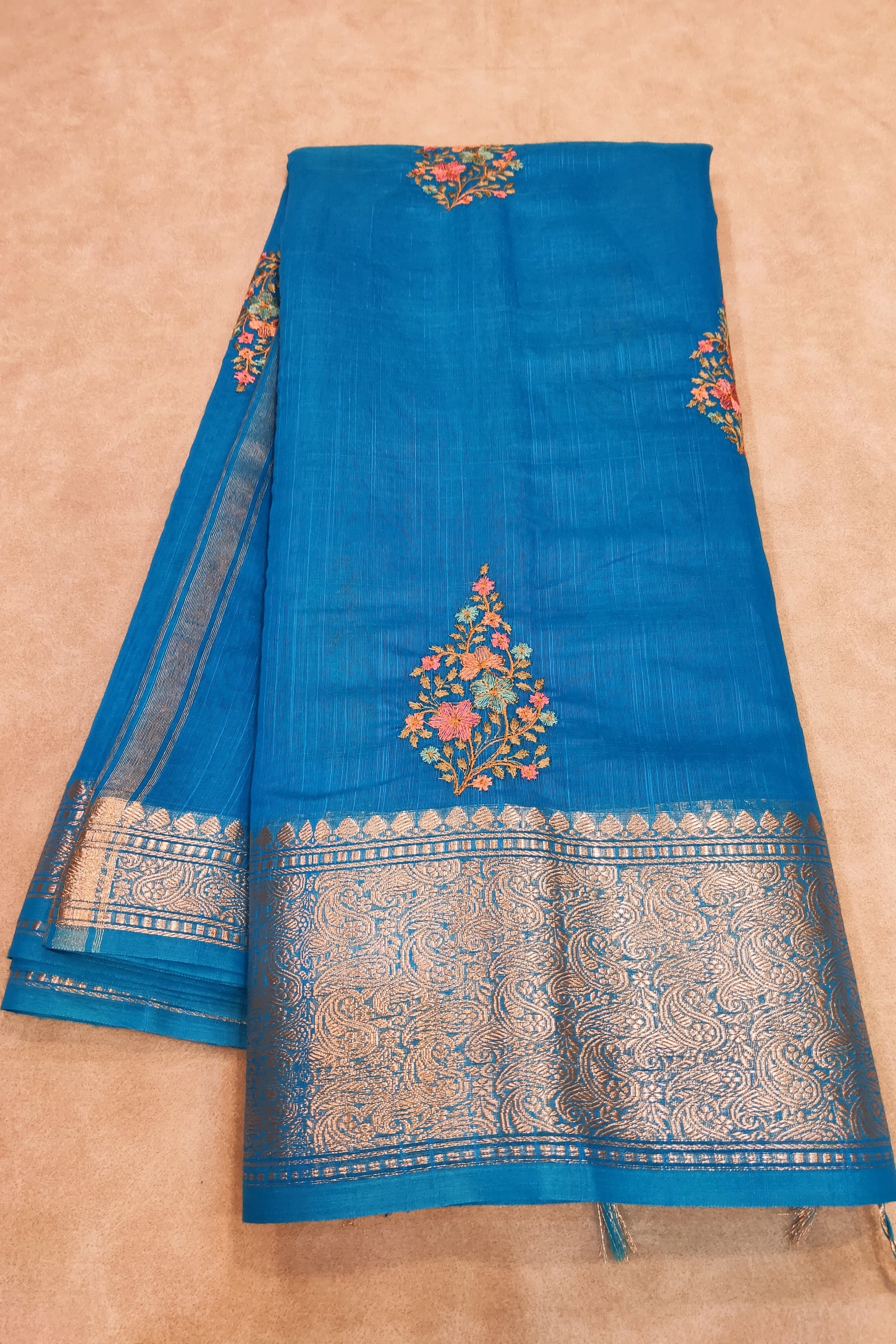 Blue fabric with intricate patterns on a beige background