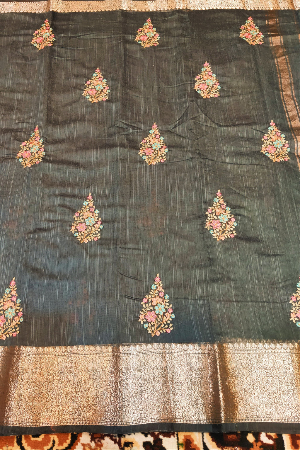 Dark blue fabric with floral embroidery on a patterned background