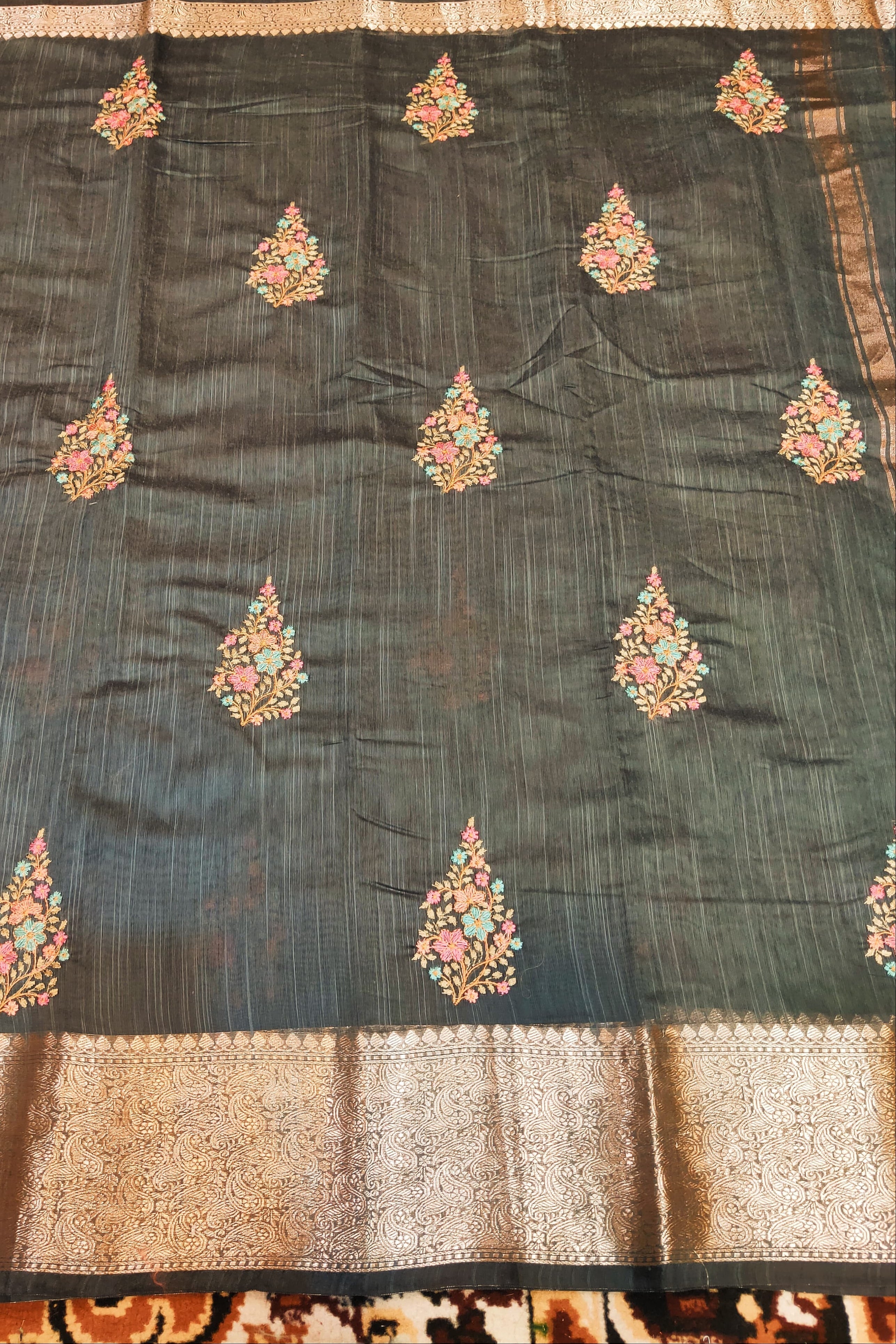 Dark blue fabric with floral embroidery on a patterned background