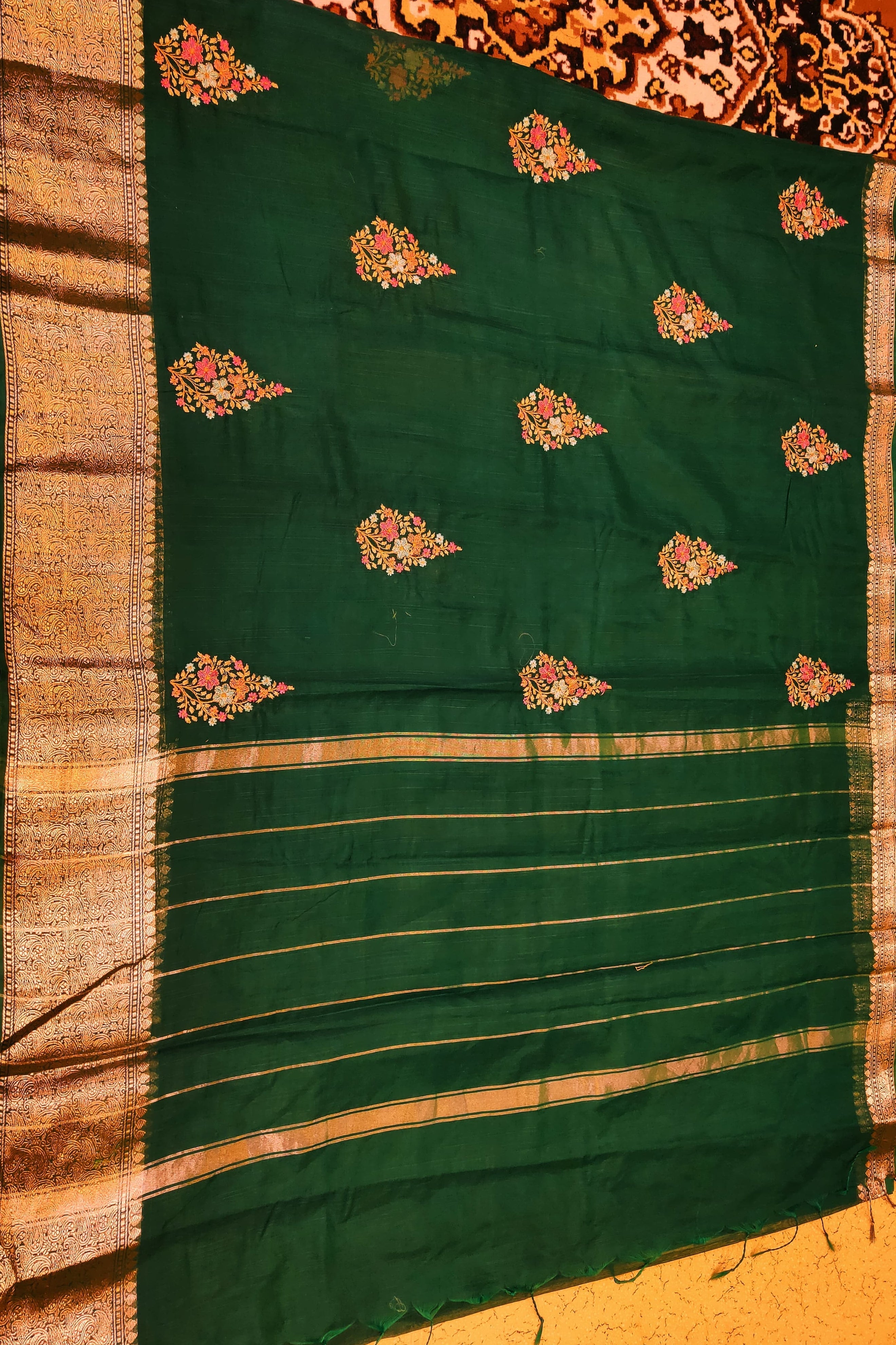 Green saree with floral patterns on a patterned background