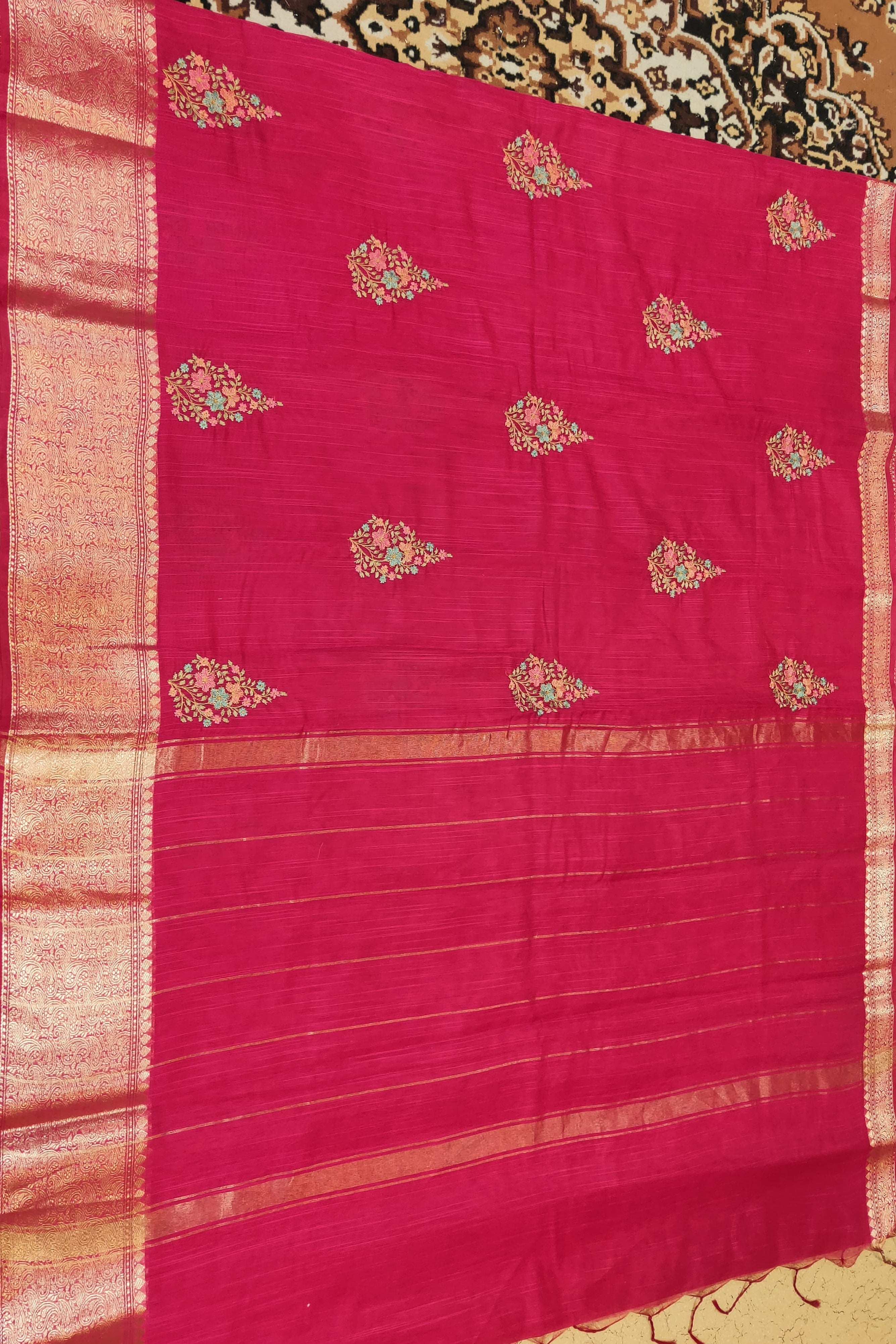 Pink saree with floral patterns on a patterned background