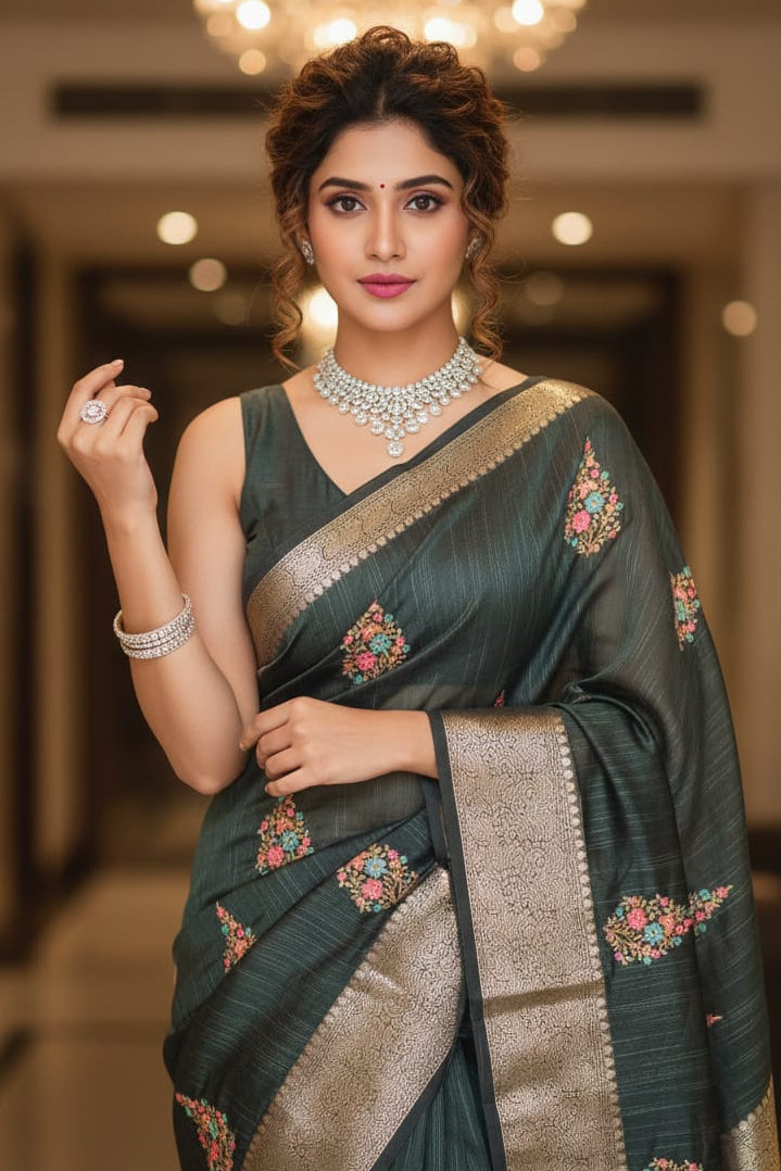 Woman in a green saree with floral patterns in an indoor setting