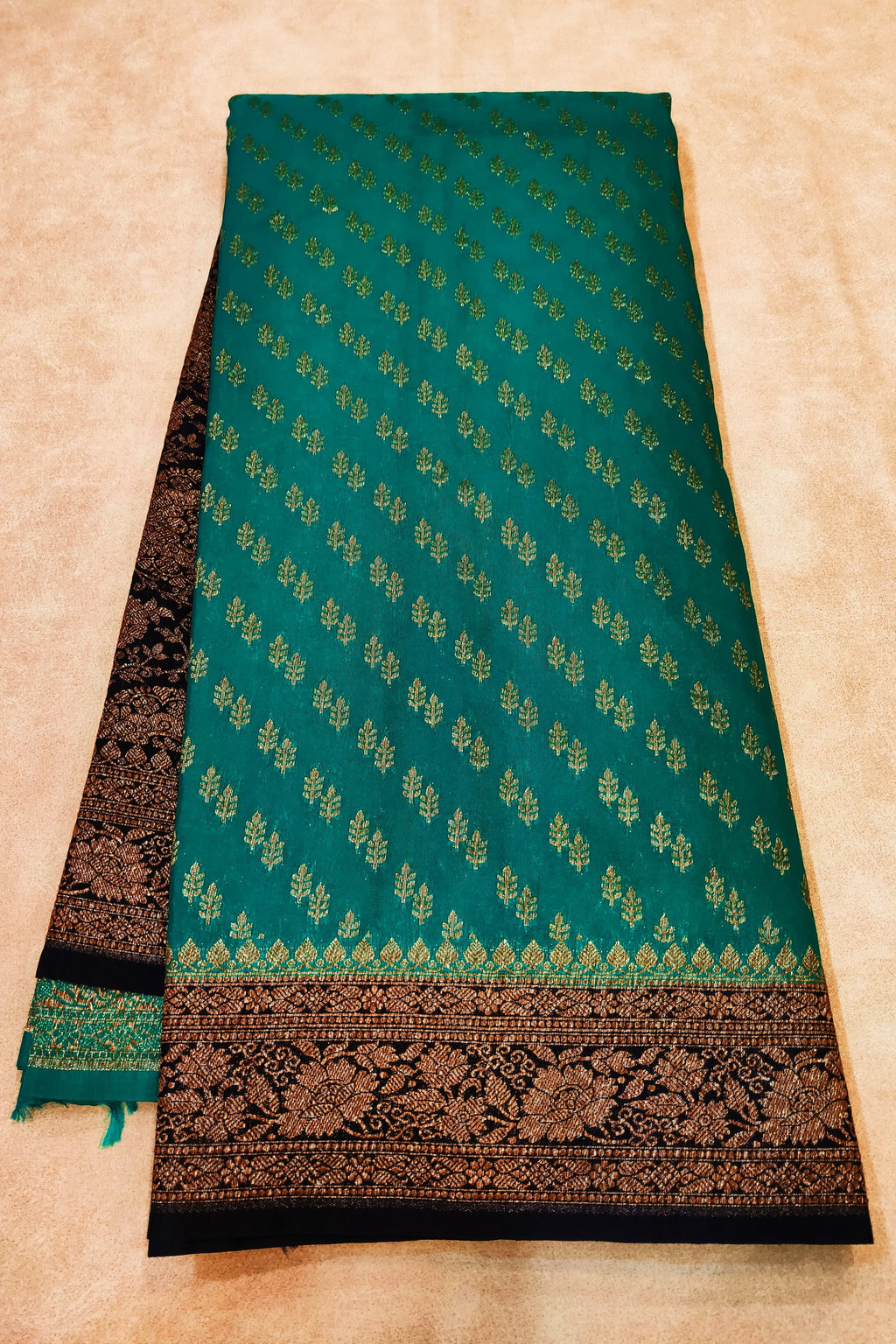 Green fabric with black border on a beige background