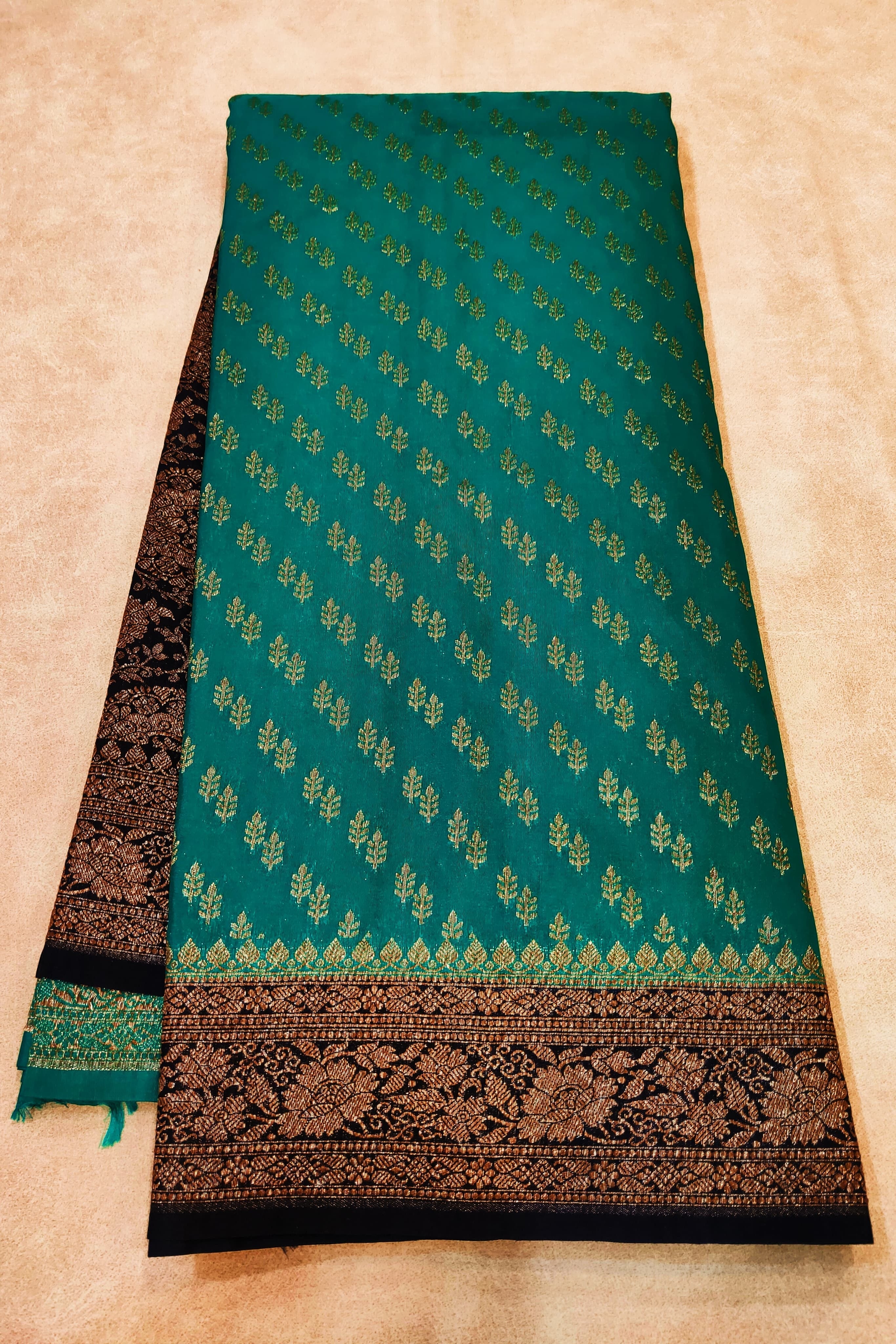 Green fabric with black border on a beige background