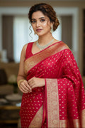 Woman in a red saree with gold patterns indoors