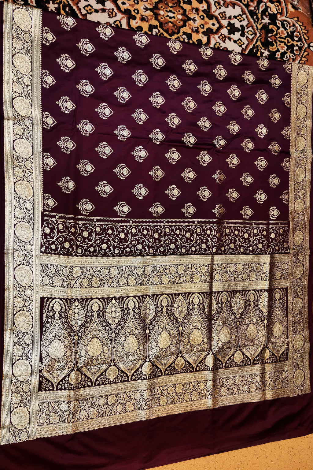 Decorative purple fabric with intricate white patterns on a wooden surface