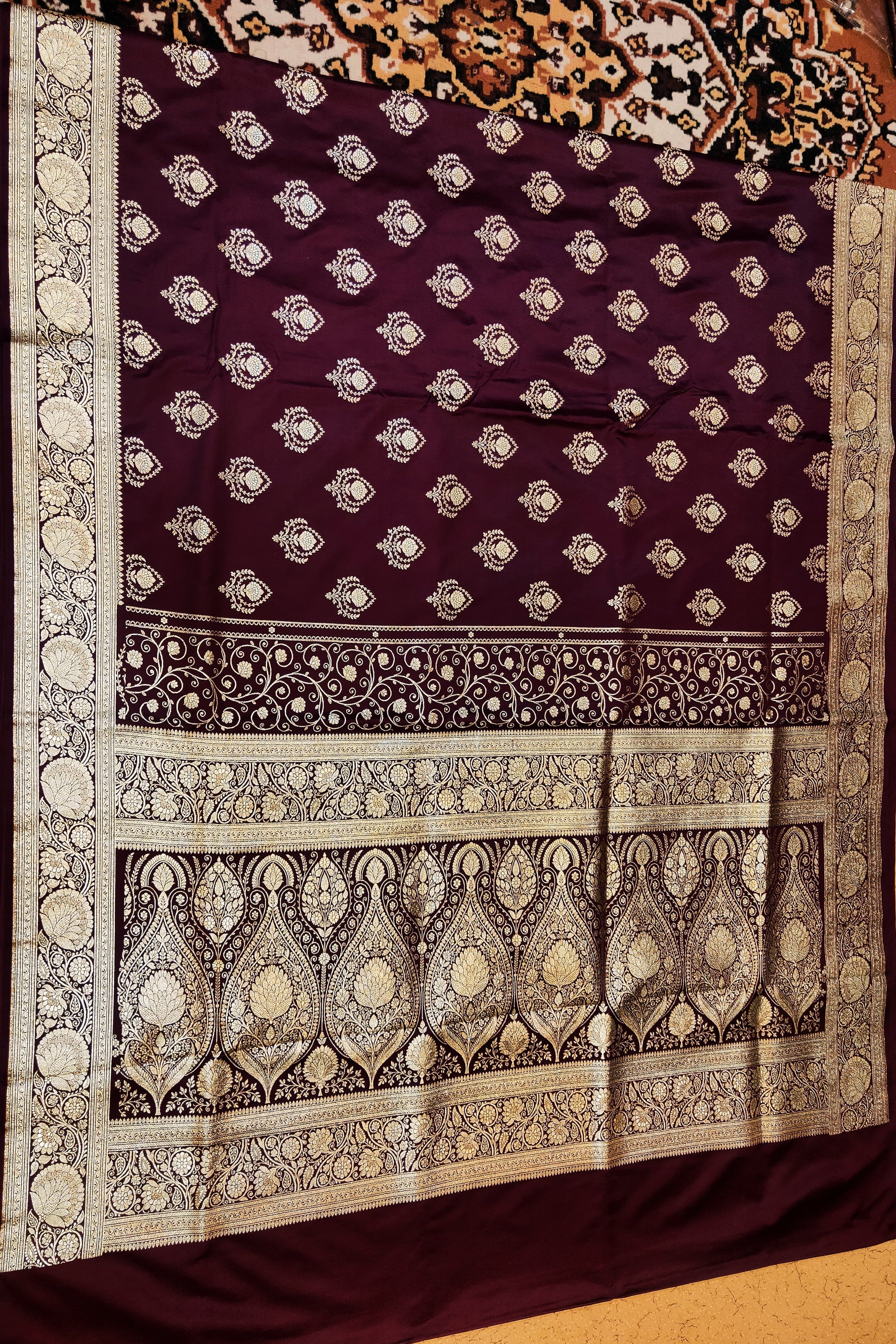 Decorative purple fabric with intricate white patterns on a wooden surface