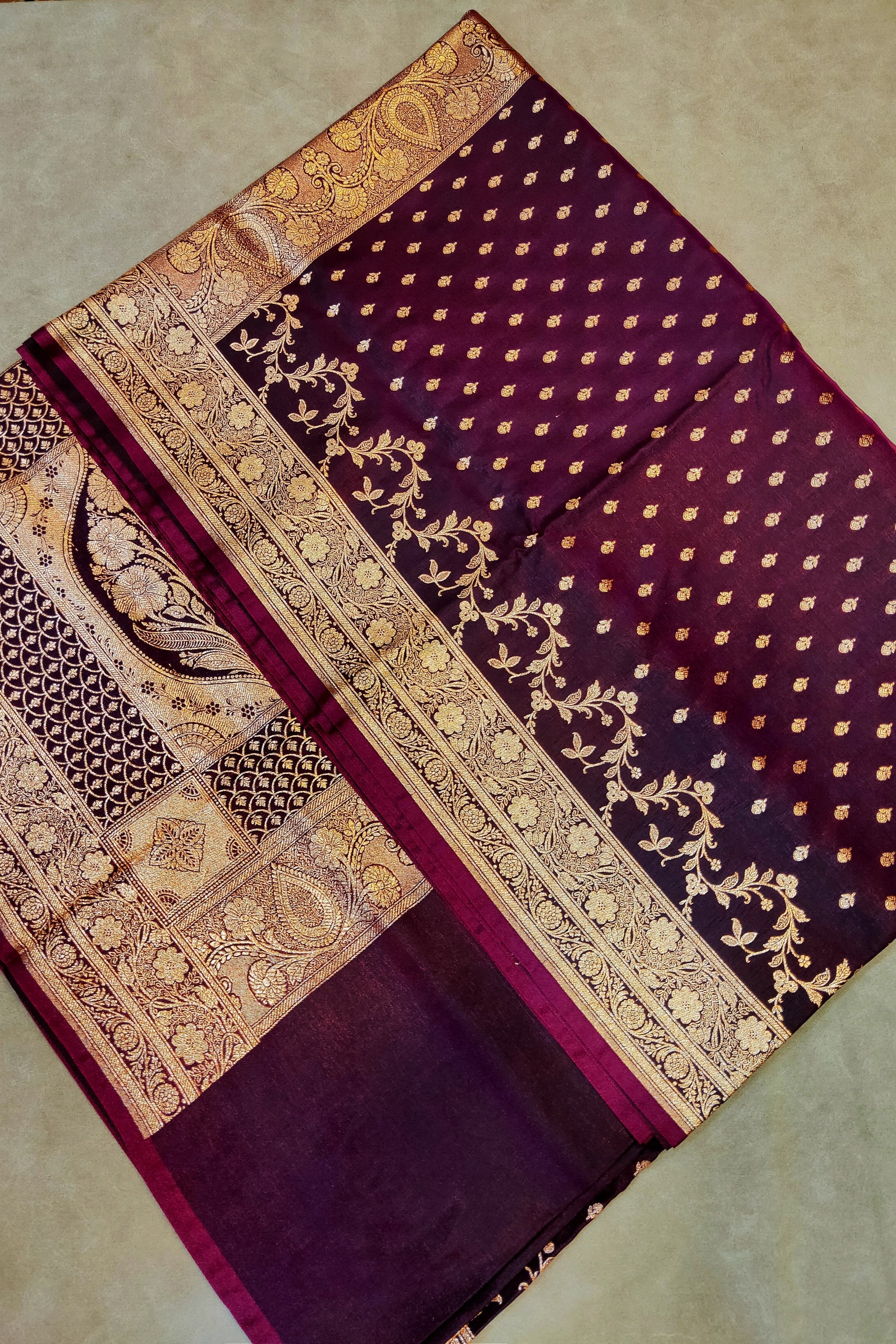 Purple fabric with gold embroidery on a beige background