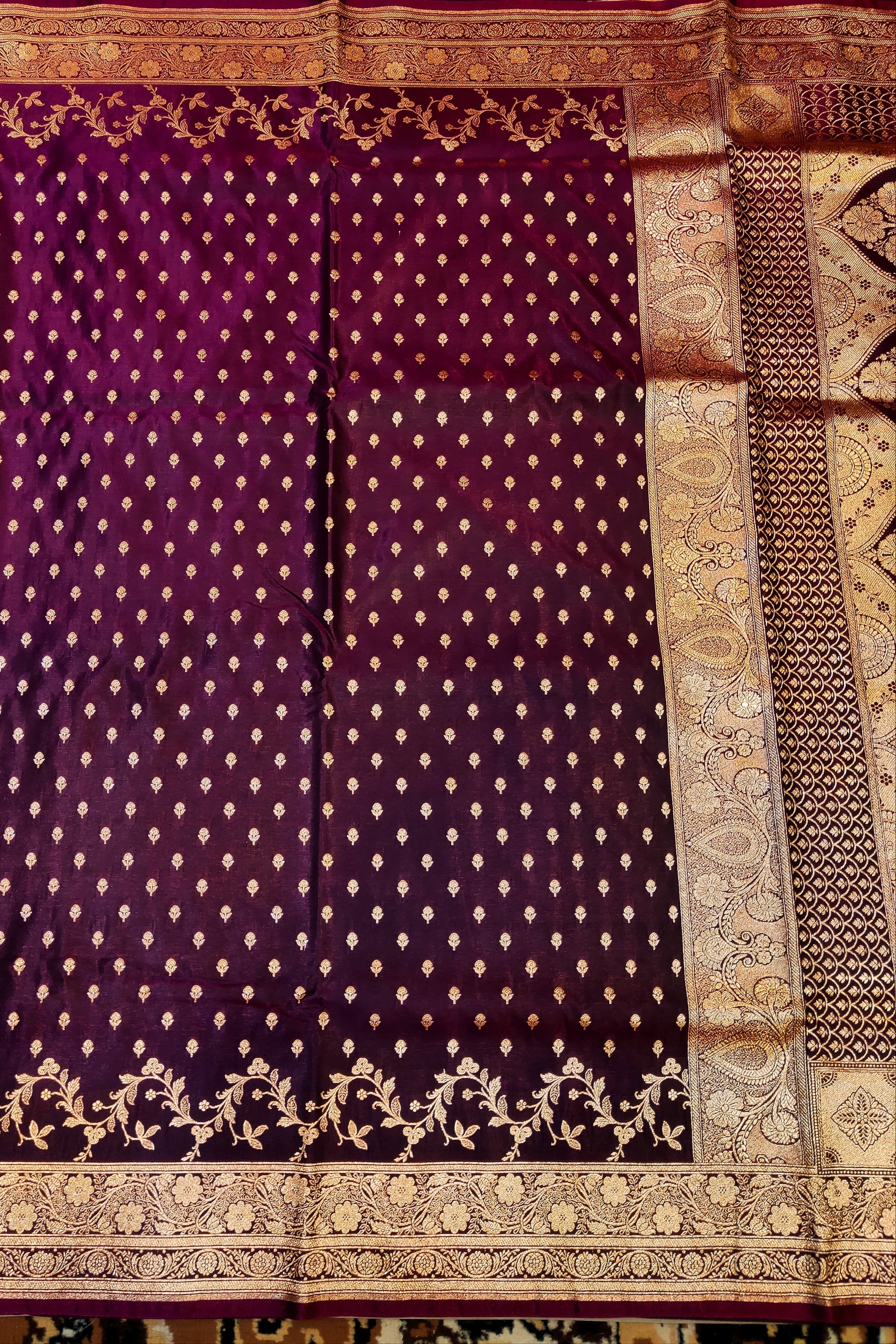 Purple saree with gold patterns on a textured background
