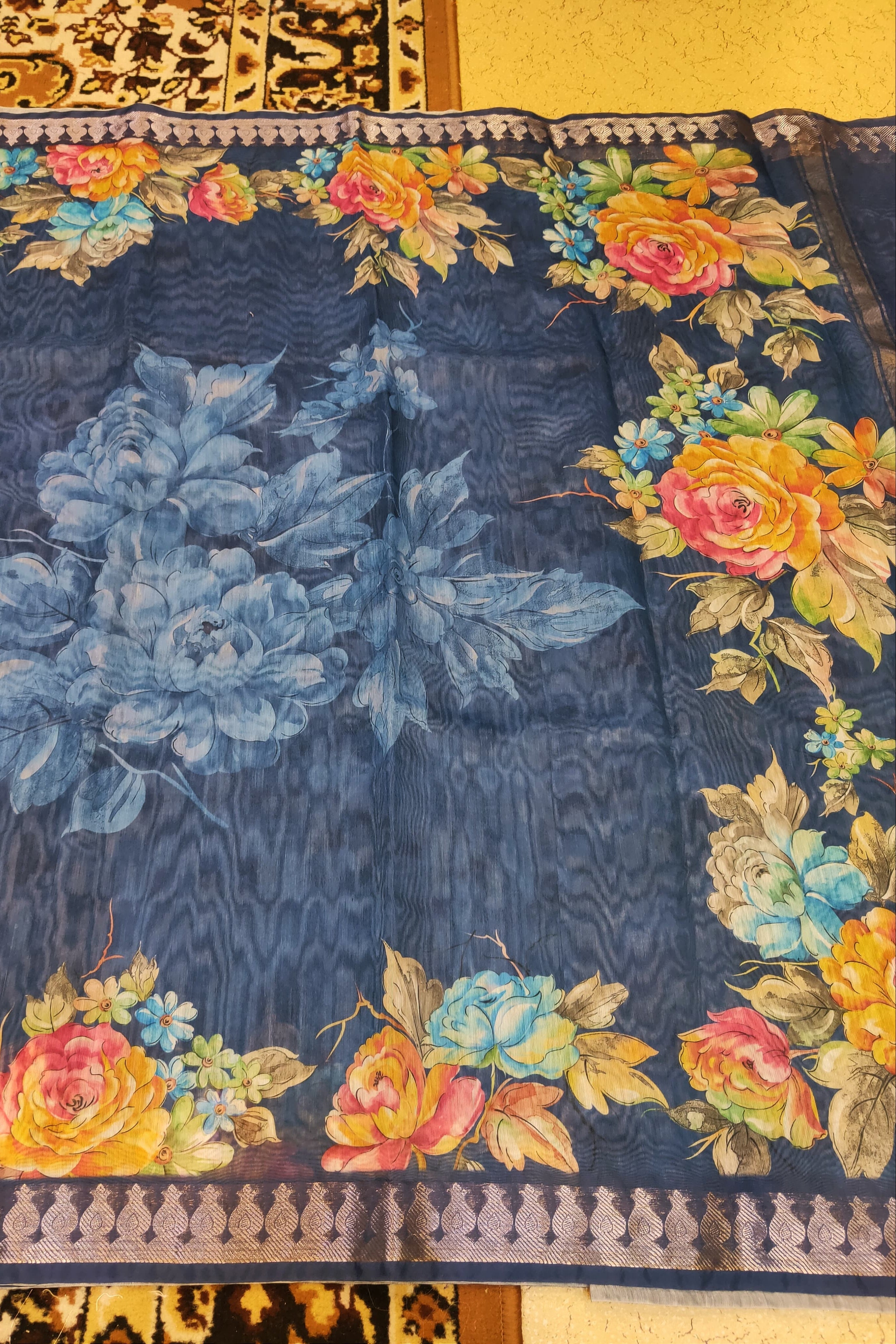 Floral patterned fabric with blue base and colorful flowers on a yellow background