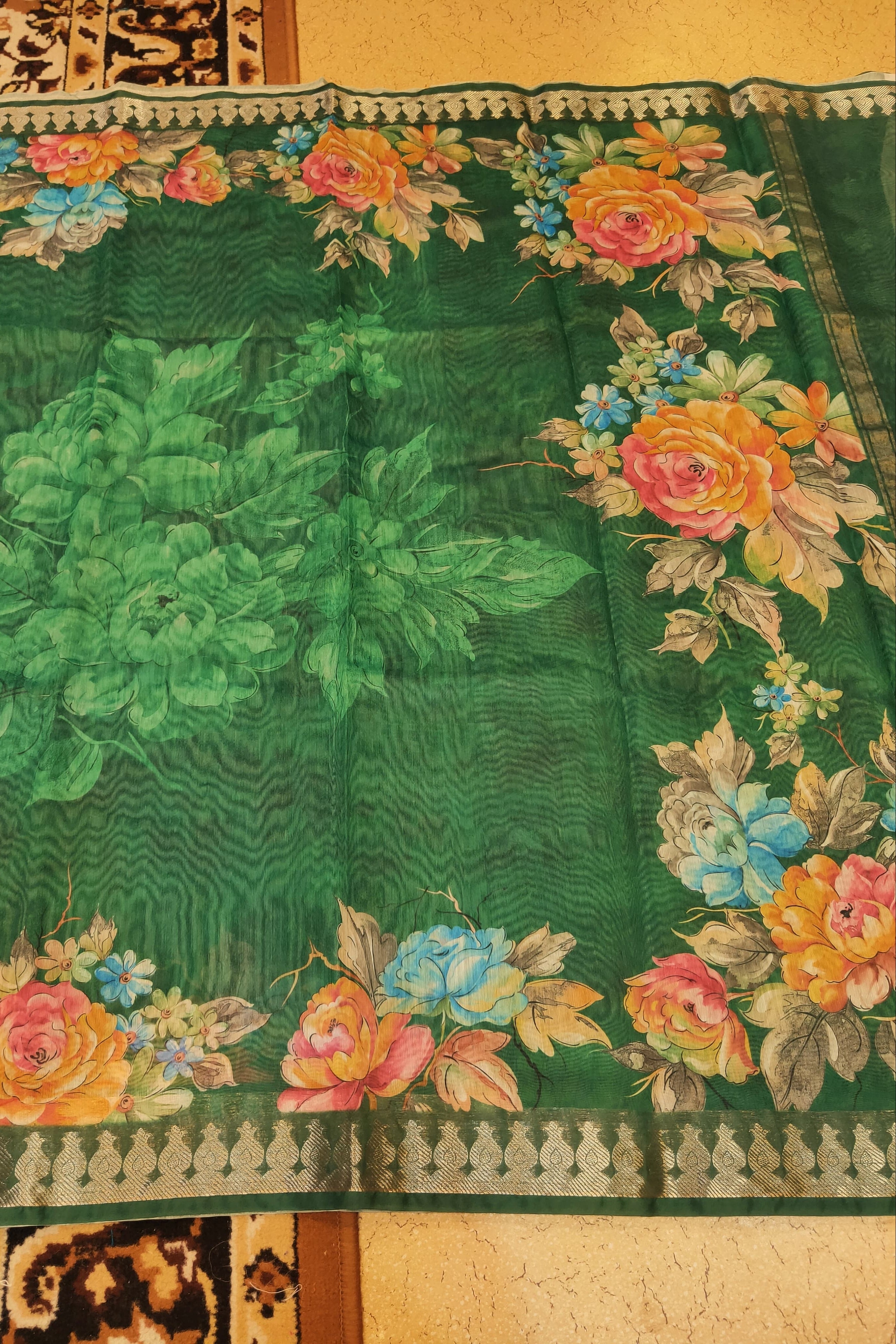 Green fabric with floral patterns and embroidery on a textured surface
