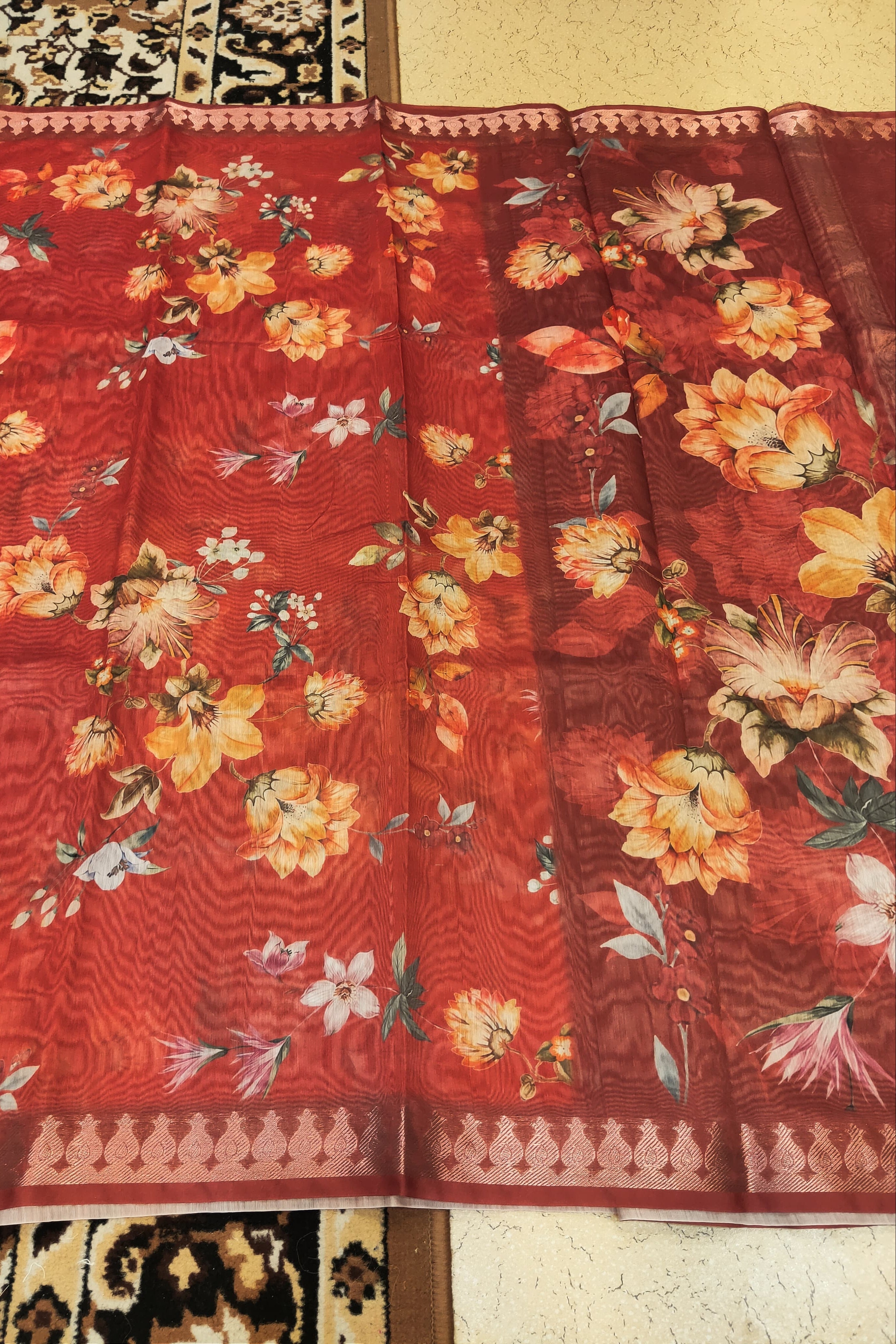 Red floral fabric with a pattern of flowers and leaves on a plain background