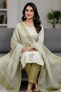 Woman sitting on a couch wearing a light green dupatta and white kurta with gold patterns.
