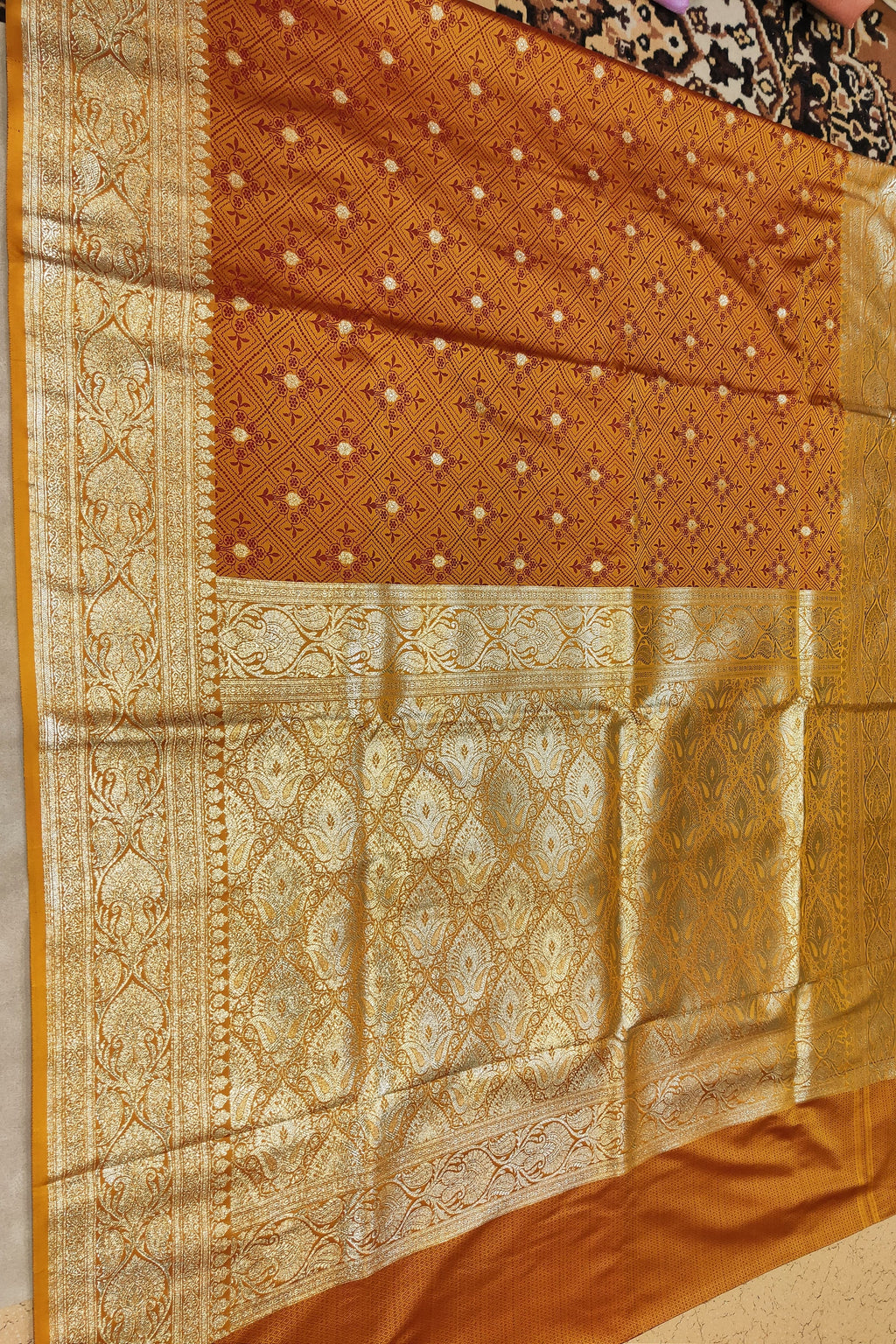 Brown saree with intricate patterns on a neutral background