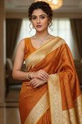Woman wearing an orange saree with a blurred indoor background
