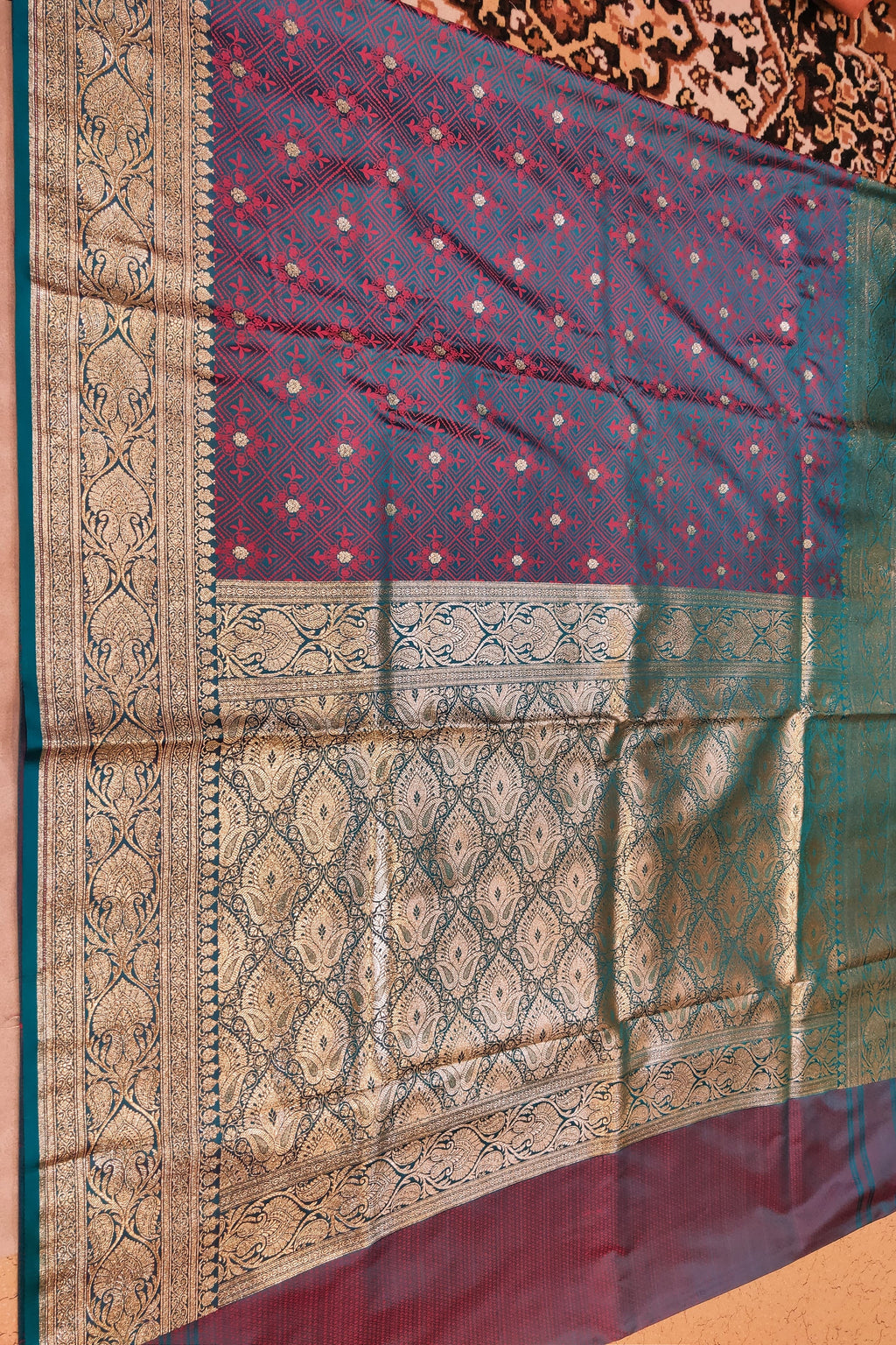 Traditional saree with intricate patterns on a plain background