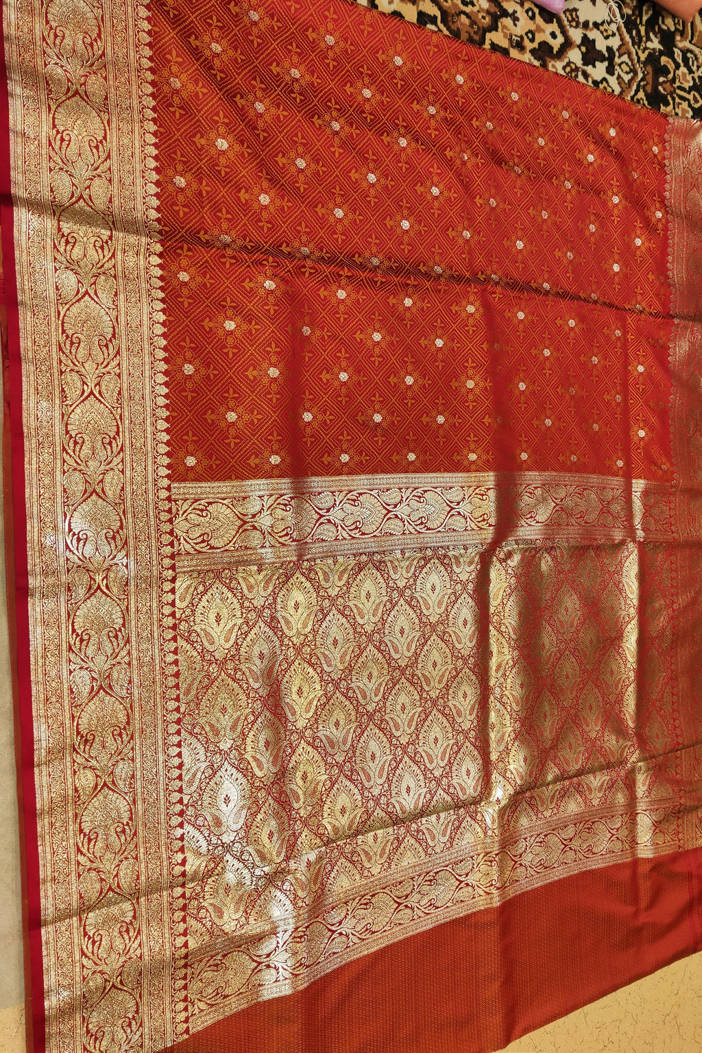 Red and gold patterned fabric on a plain background
